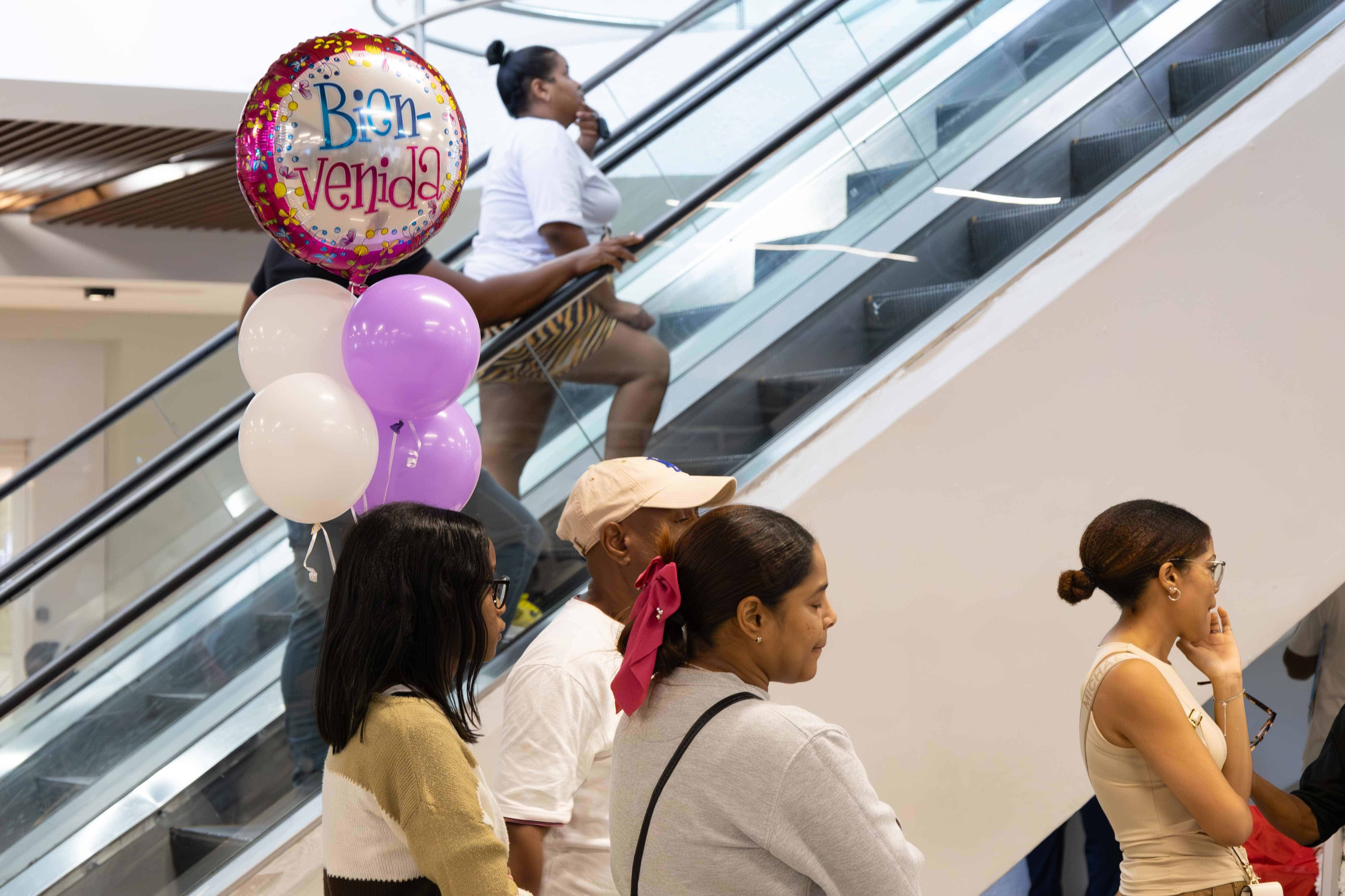 Una mujer sostiene unos globos para dar la bienvenida a uno de los pasajeros que arribaron al Aeropuerto Internacional Las Américas (AILA) el domingo 22 de diciembre de 2024.