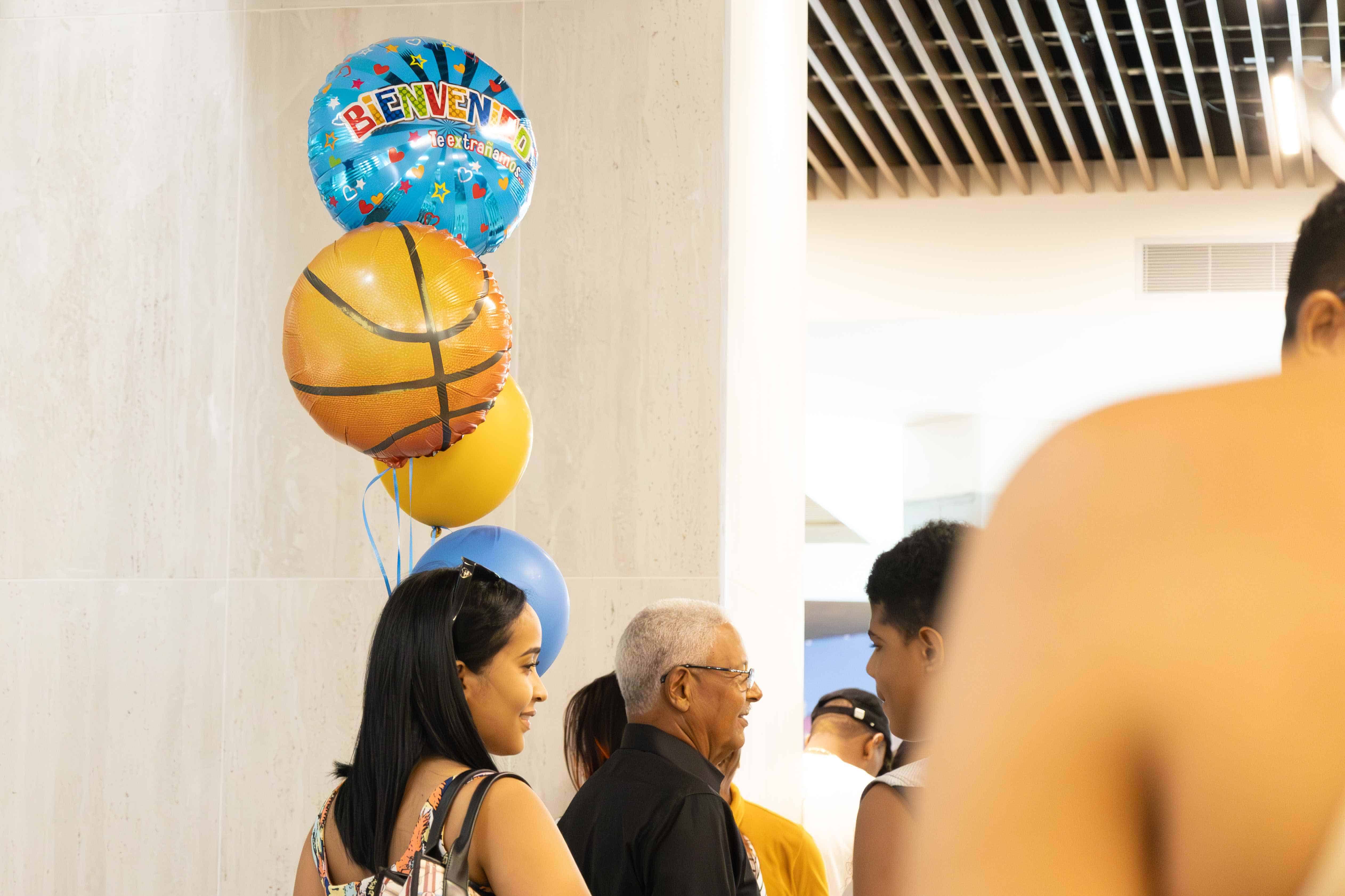 Una mujer sostiene unos globos para dar la bienvenida a uno de los pasajeros que arribaron al Aeropuerto Internacional Las Américas (AILA) el domingo 22 de diciembre de 2024.