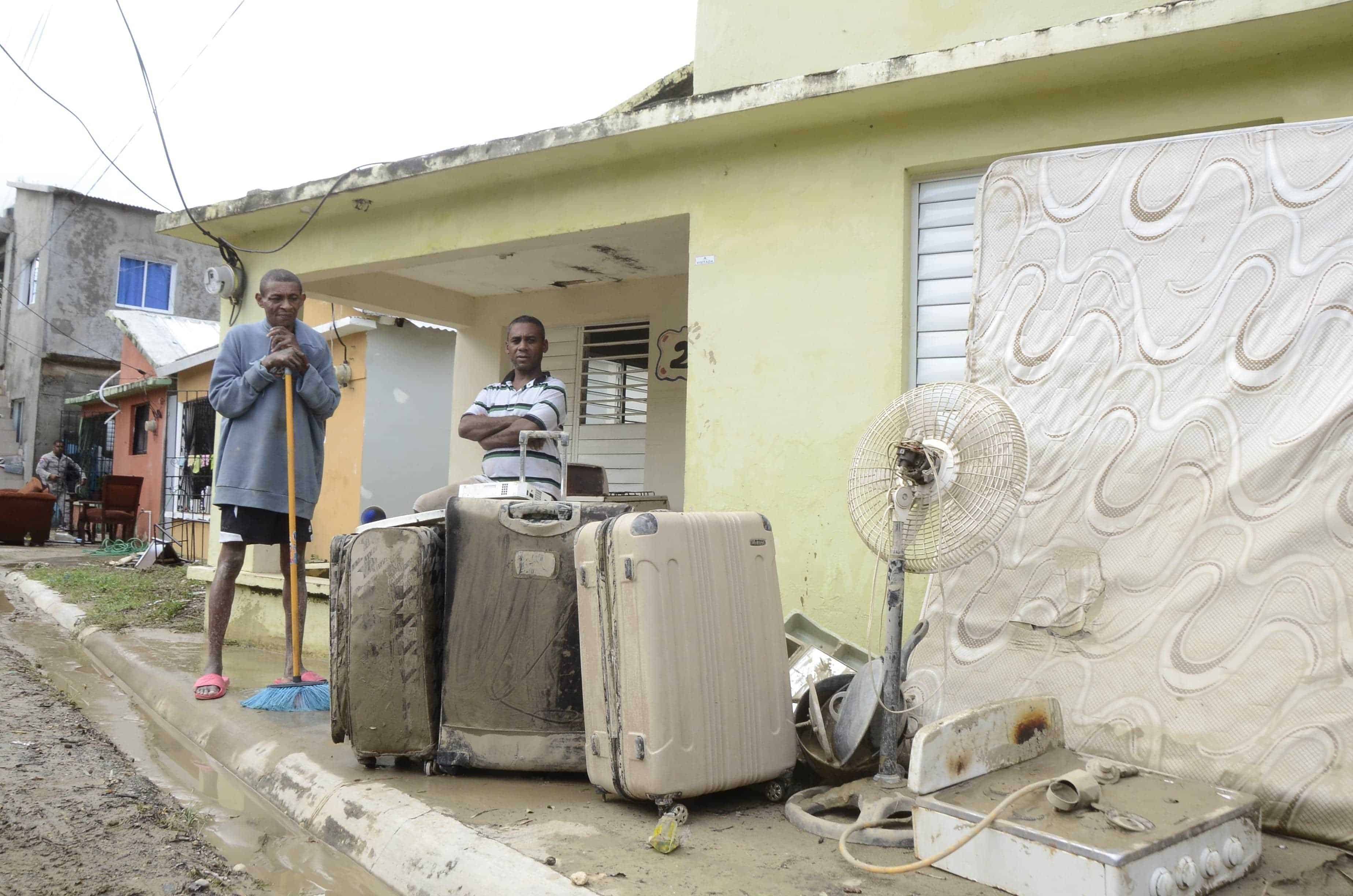 Personas limpian sus casas y tratan de secar sus ajuares afectados por las lluvias en Puerto Plata.