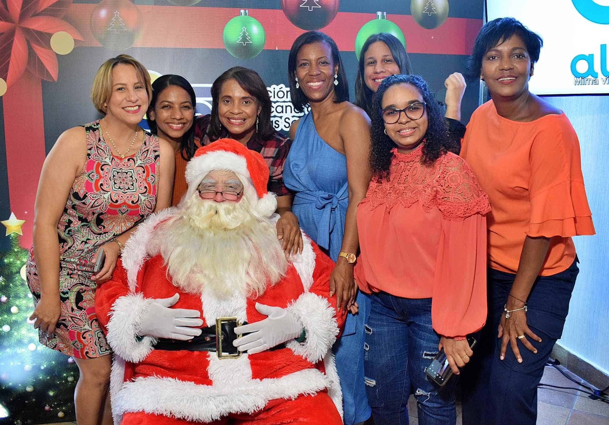 Santa rodeado de Yohanna Hilario, Shawel Peña, Maritza Morillo, Lidia Mora, Lisbel Sánchez, Anibelca Martinez y Yuberkys Mejía.