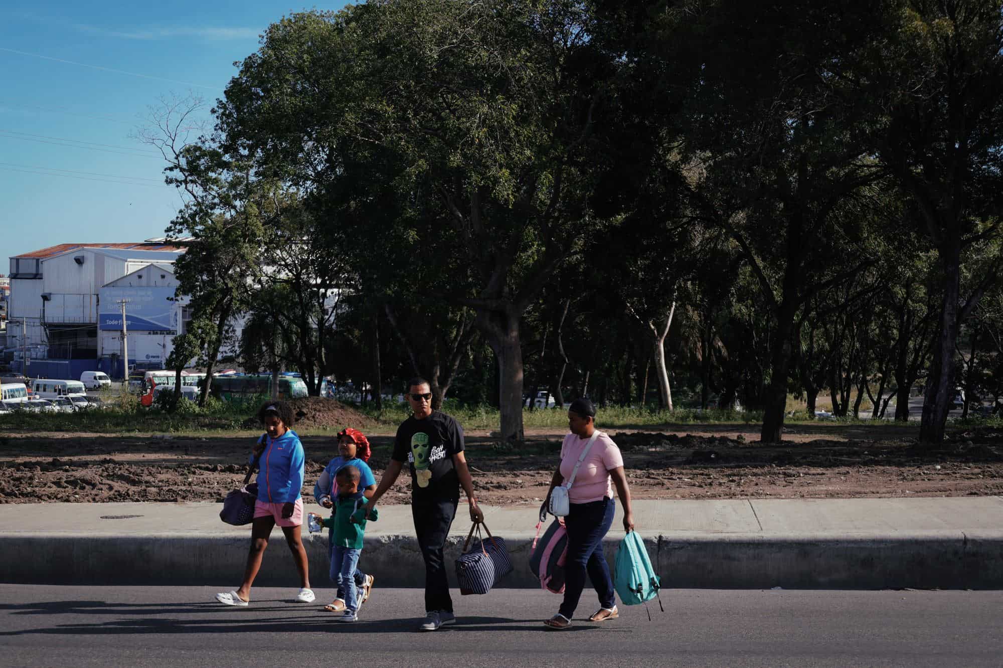 Una familia se dirige al terminal de pasajeros ubicado en el kilómetro 9 de la autopista Duarte como parte del éxodo de fin de año de los capitalinos.