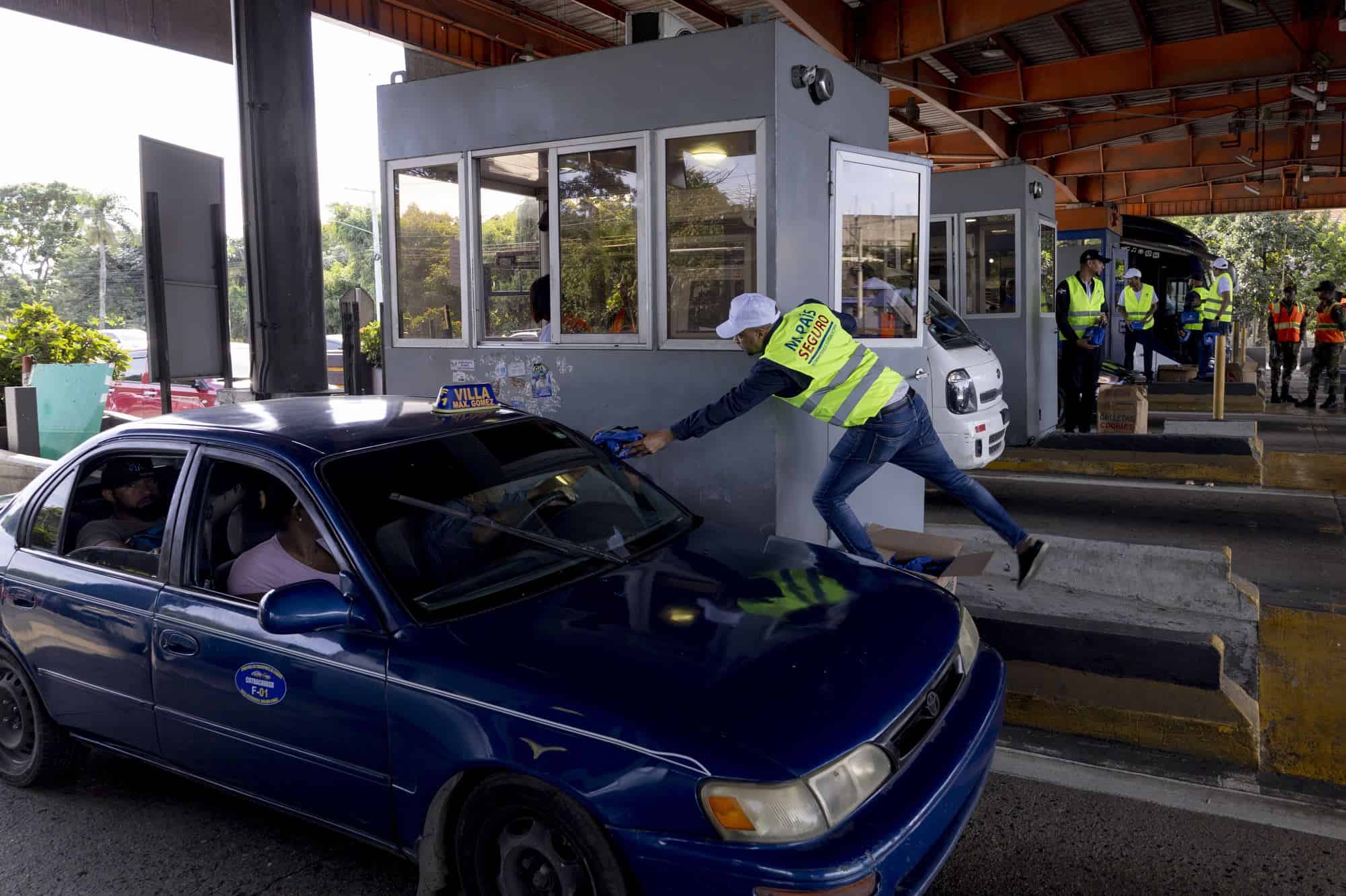 Efectivos del Ministerio de Interior y Policía entregan botiquines de primeros auxilios, a los viajeros que transitan por el peaje de la autopista Duarte.