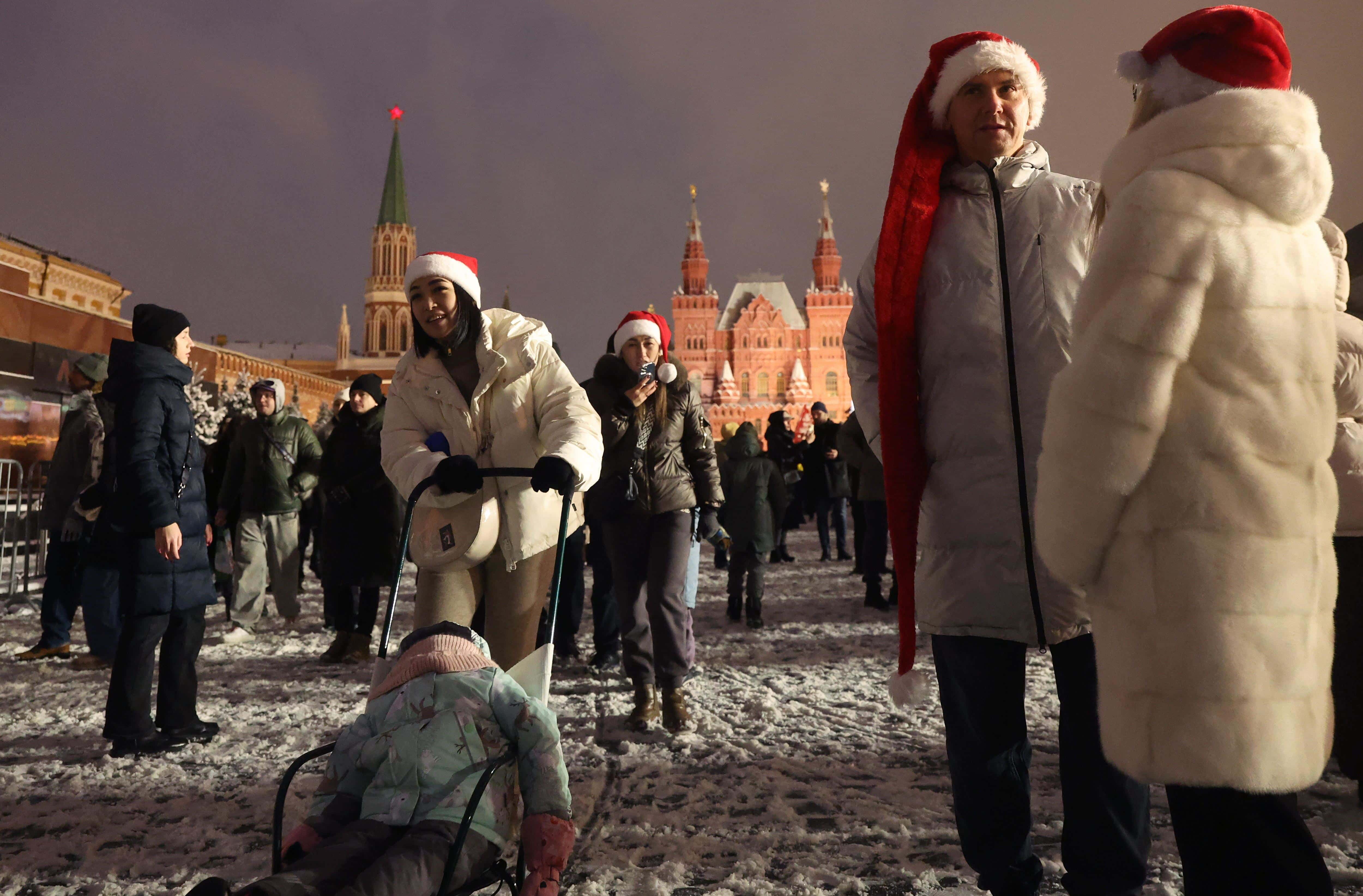 La gente camina por la Plaza Roja, frente al Kremlin, en la víspera de Año Nuevo en Moscú, Rusia, el 31 de diciembre de 2024. Los rusos se preparan para celebrar la Nochevieja el 31 de diciembre y la Navidad el 7 de enero, según el calendario juliano ortodoxo ruso. (Rusia, Moscú).