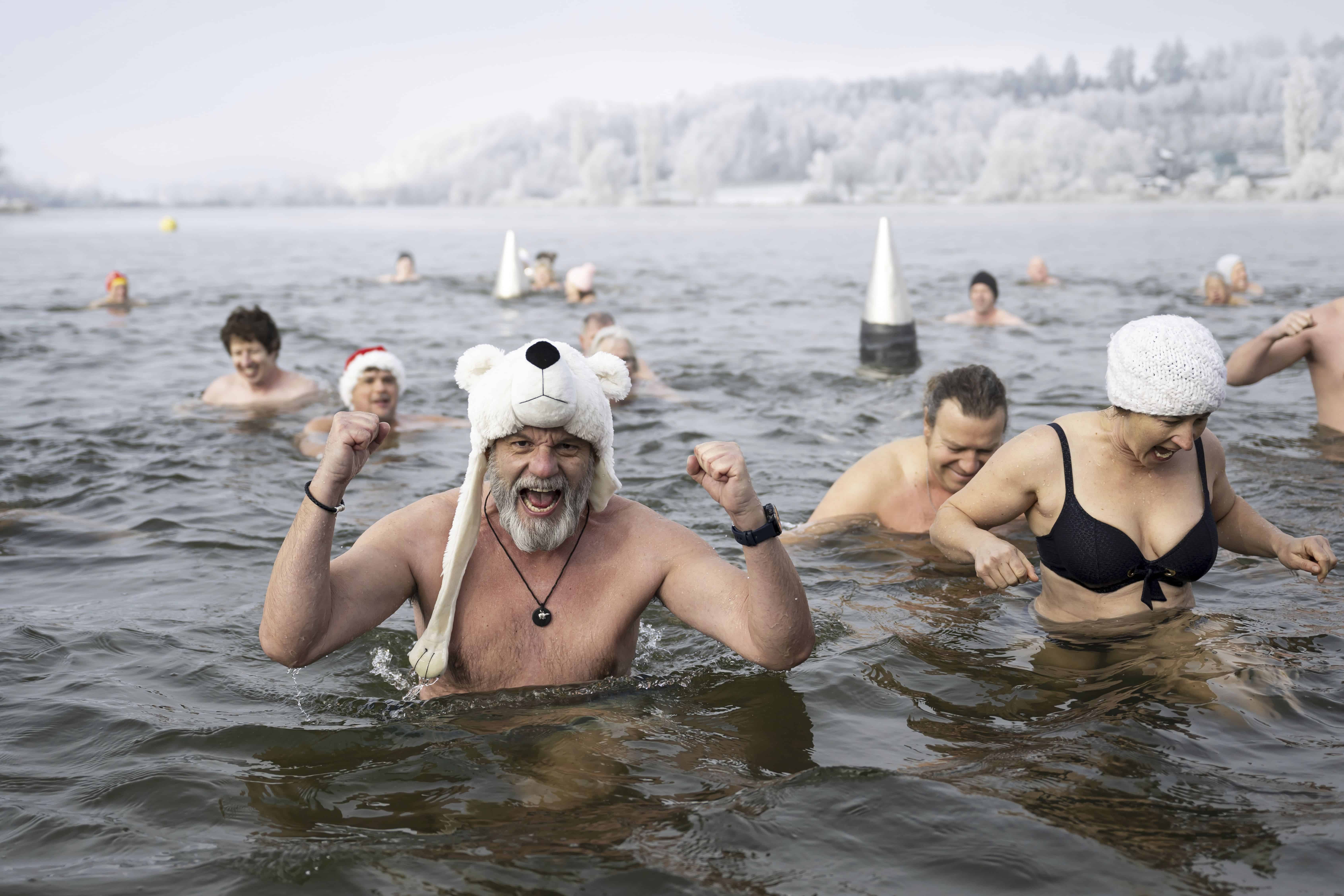 Los nadadores asisten a la tradicional natación de Nochevieja en el lago Moossee en Moosseedorf, Suiza, el martes 31 de diciembre de 2024.