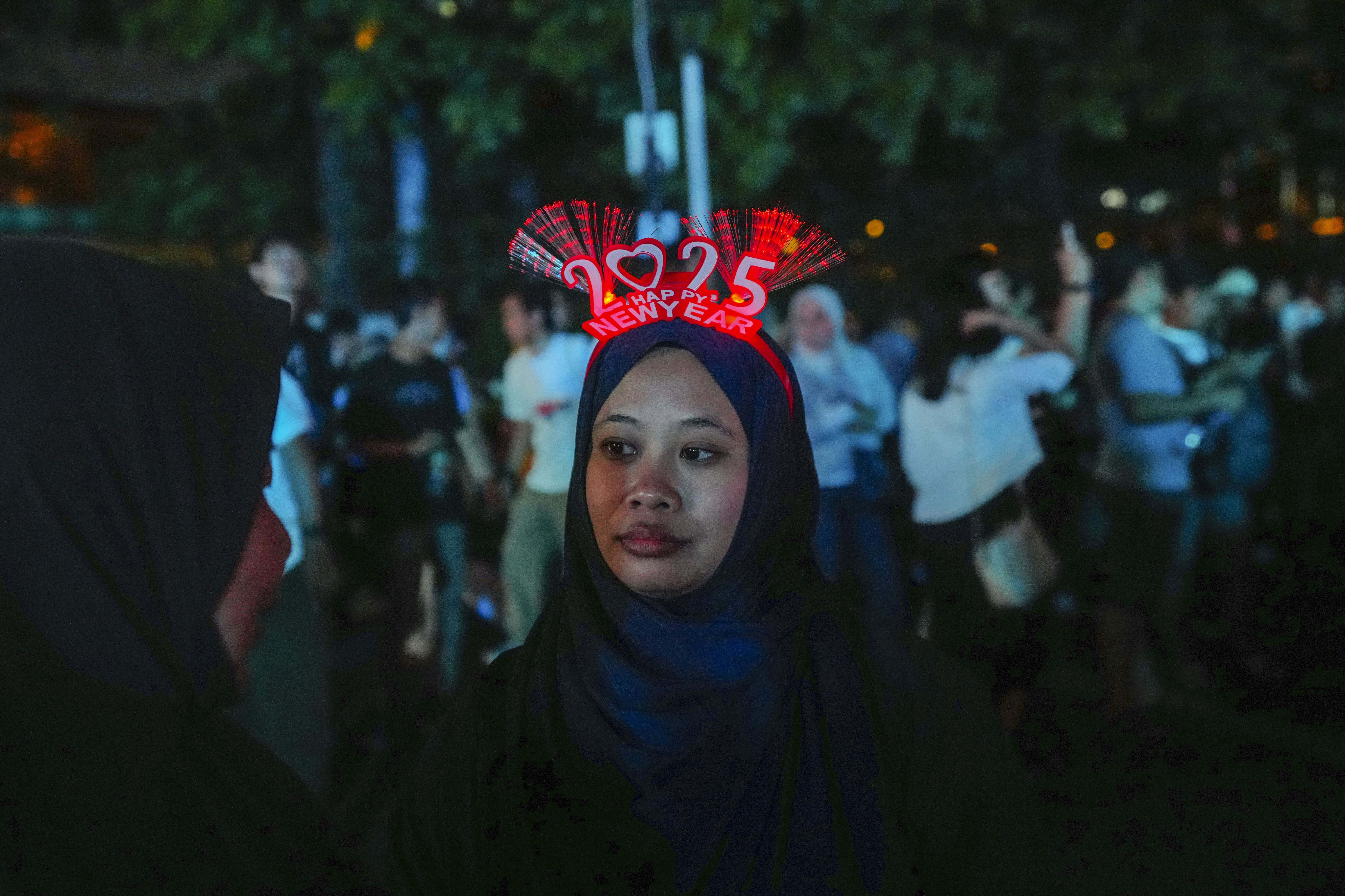 Una mujer lleva una diadema con el número 2025 en el principal distrito comercial de Yakarta, Indonesia, el martes 31 de diciembre de 2024.