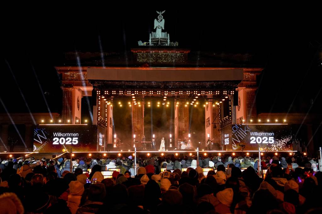 La gente se reúne cerca de la Puerta de Brandeburgo para celebrar y ver los fuegos artificiales de las celebraciones de Año Nuevo en Berlín, Alemania, el martes 31 de diciembre de 2024.