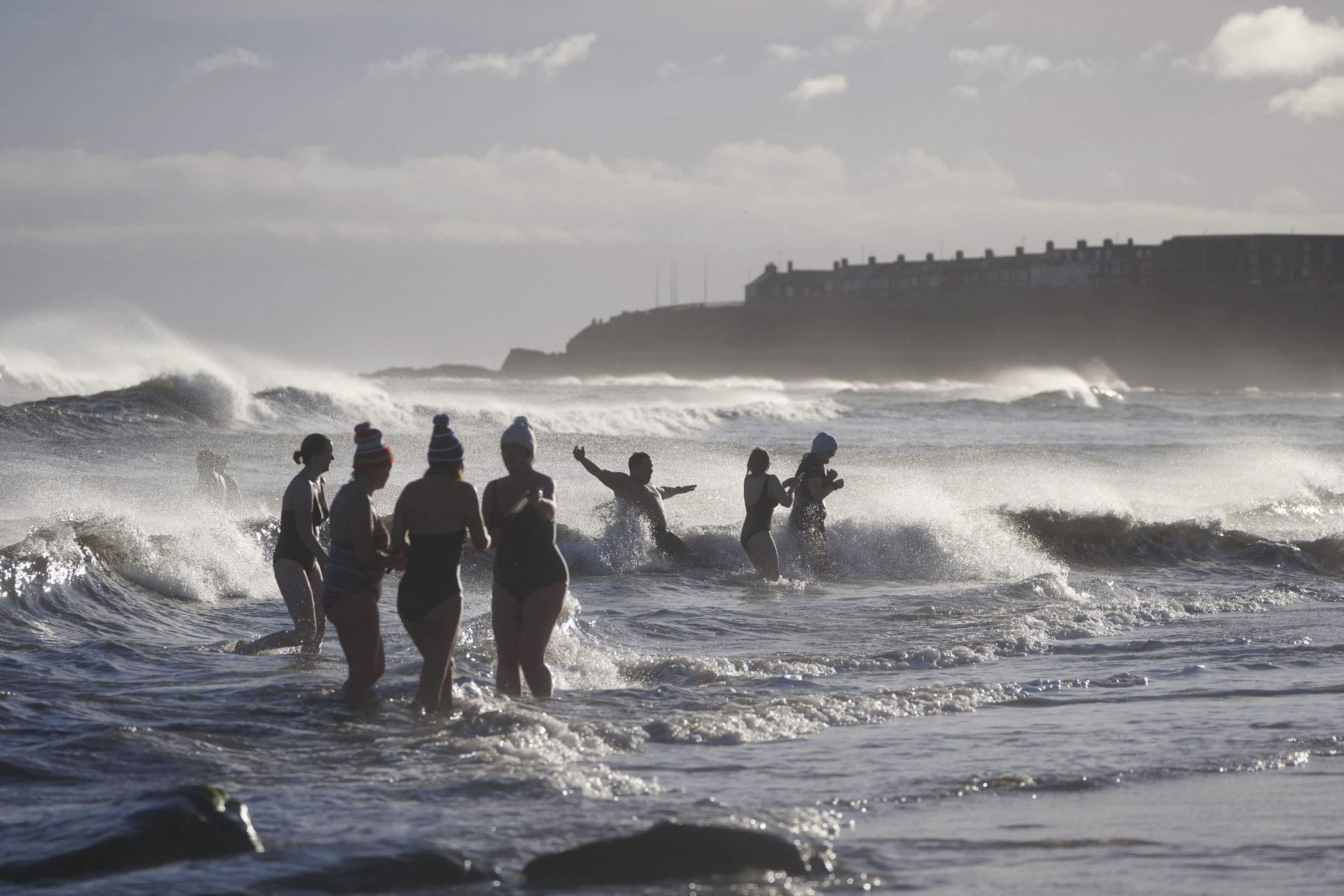 Nadadores se sumergen en el mar en Whitley Bay, noreste de Inglaterra, el miércoles 1 de enero de 2025.