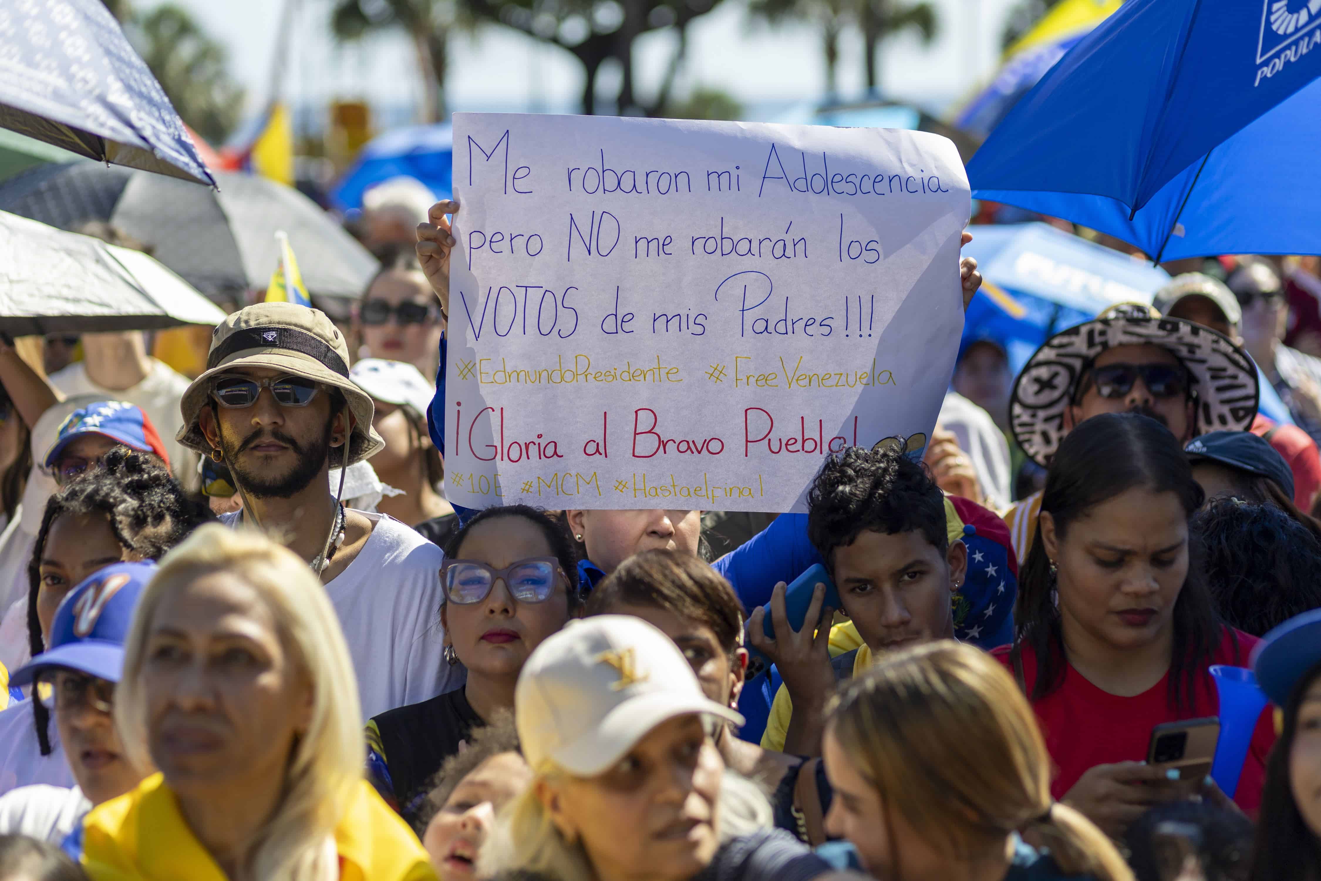 Una joven venezolana sostiene una pancarta con un mensaje en el que pide la libertad de Venezuela.