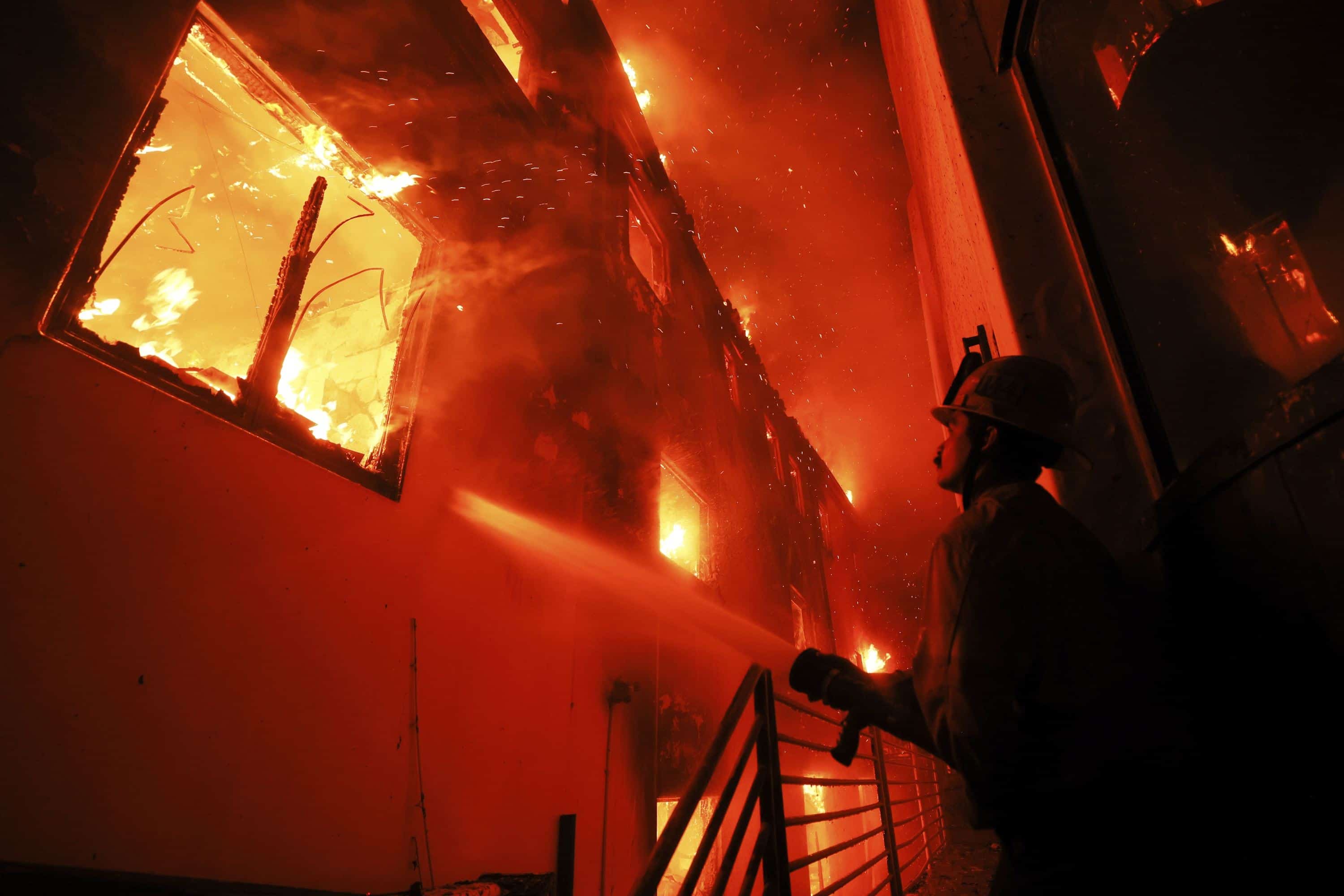 Un bombero trabaja desde una cubierta mientras el incendio de Palisades quema una propiedad frente a la playa el miércoles 8 de enero de 2025 en Malibú, California.