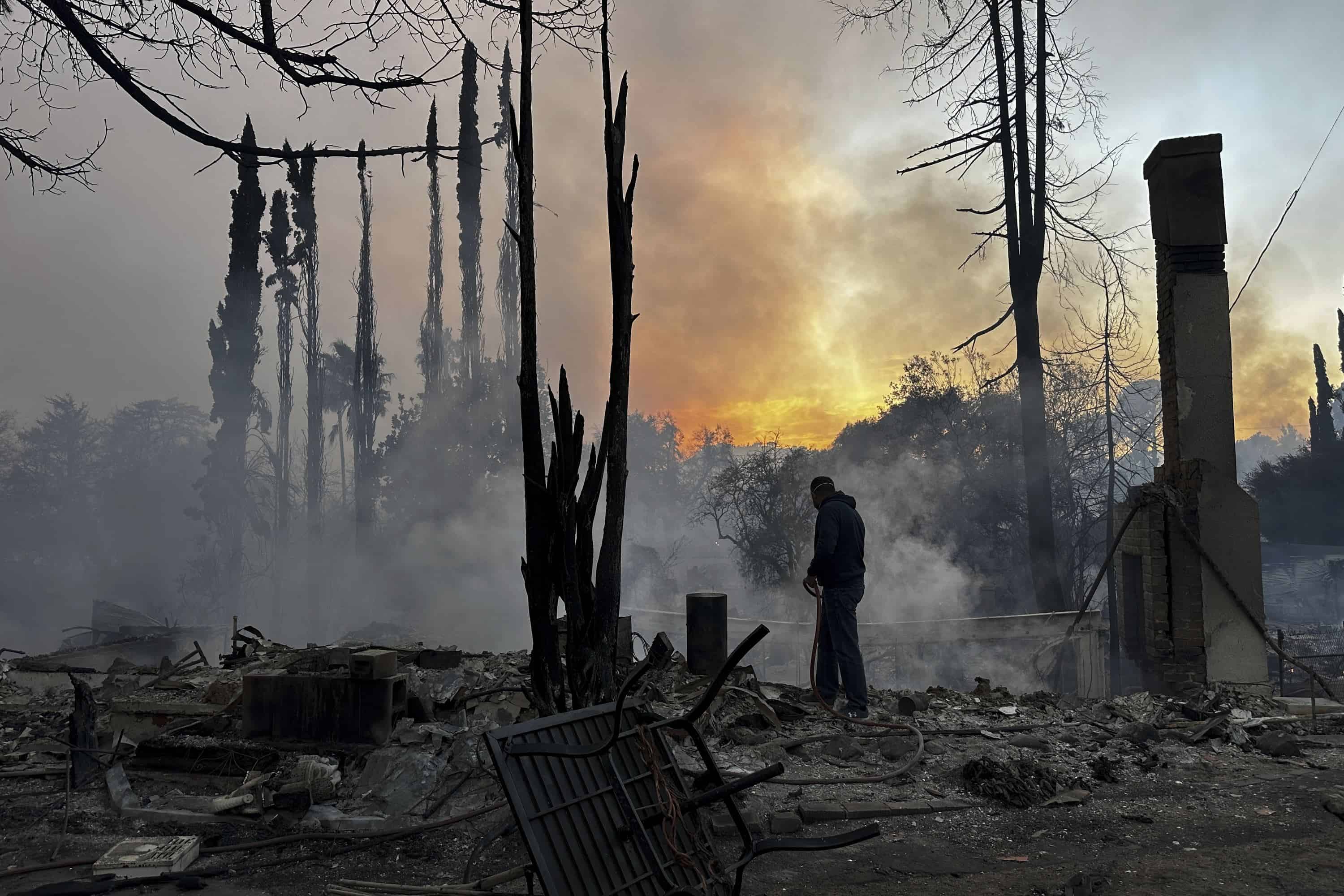 Un residente baja por puntos calientes en una propiedad devastada por el fuego después de que el incendio de Palisades arrasara en el vecindario de Pacific Palisades de Los Ángeles, el miércoles 8 de enero de 2025.