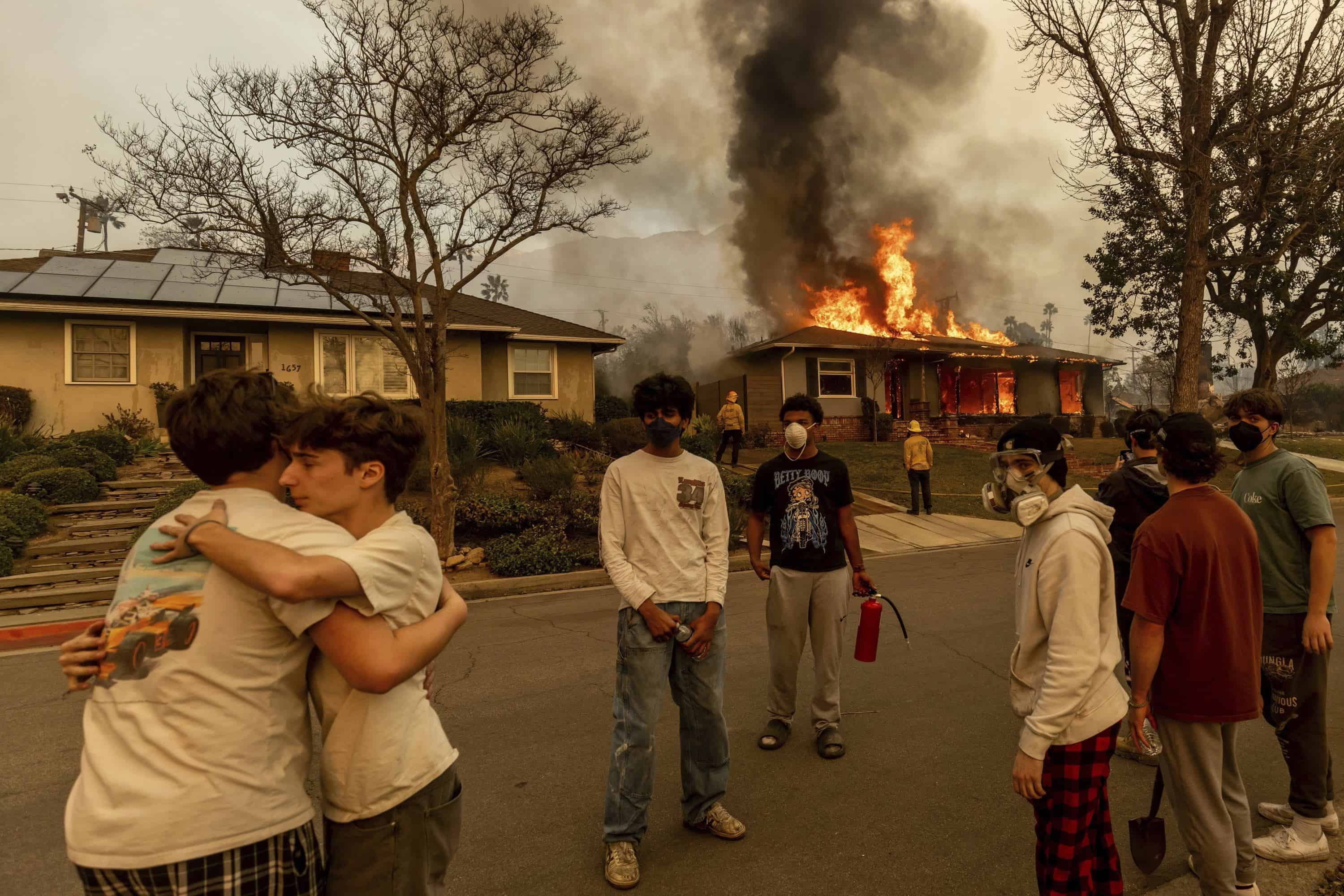 Los residentes se abrazan fuera de una propiedad en llamas mientras el incendio de Eaton se extiendía hasta el miércoles 8 de enero de 2025 en Altadena, California.