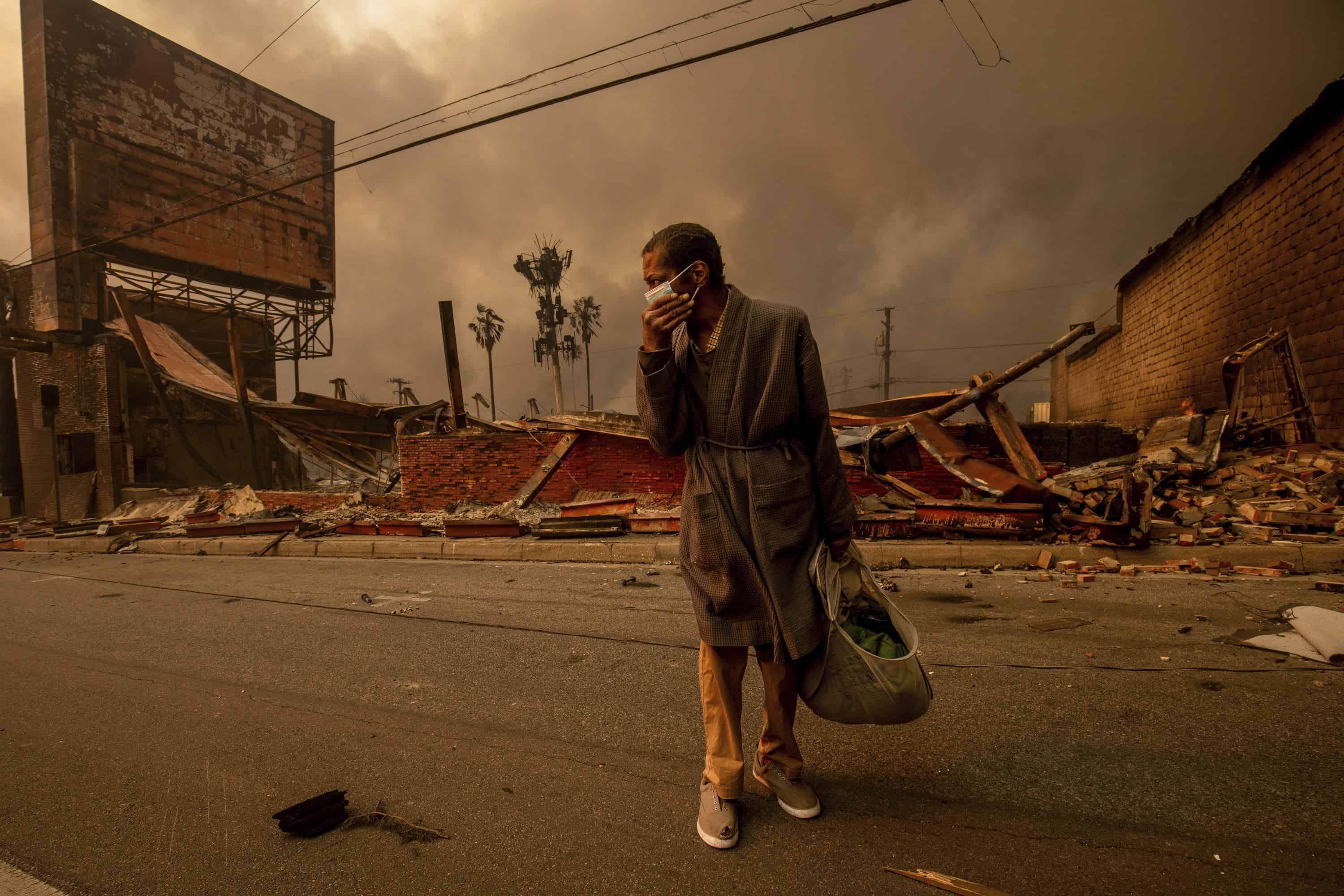 Un hombre pasa junto a un negocio devastado por un incendio después de que el incendio de Eaton se extendiera el miércoles 8 de enero de 2025 en Altadena, California.