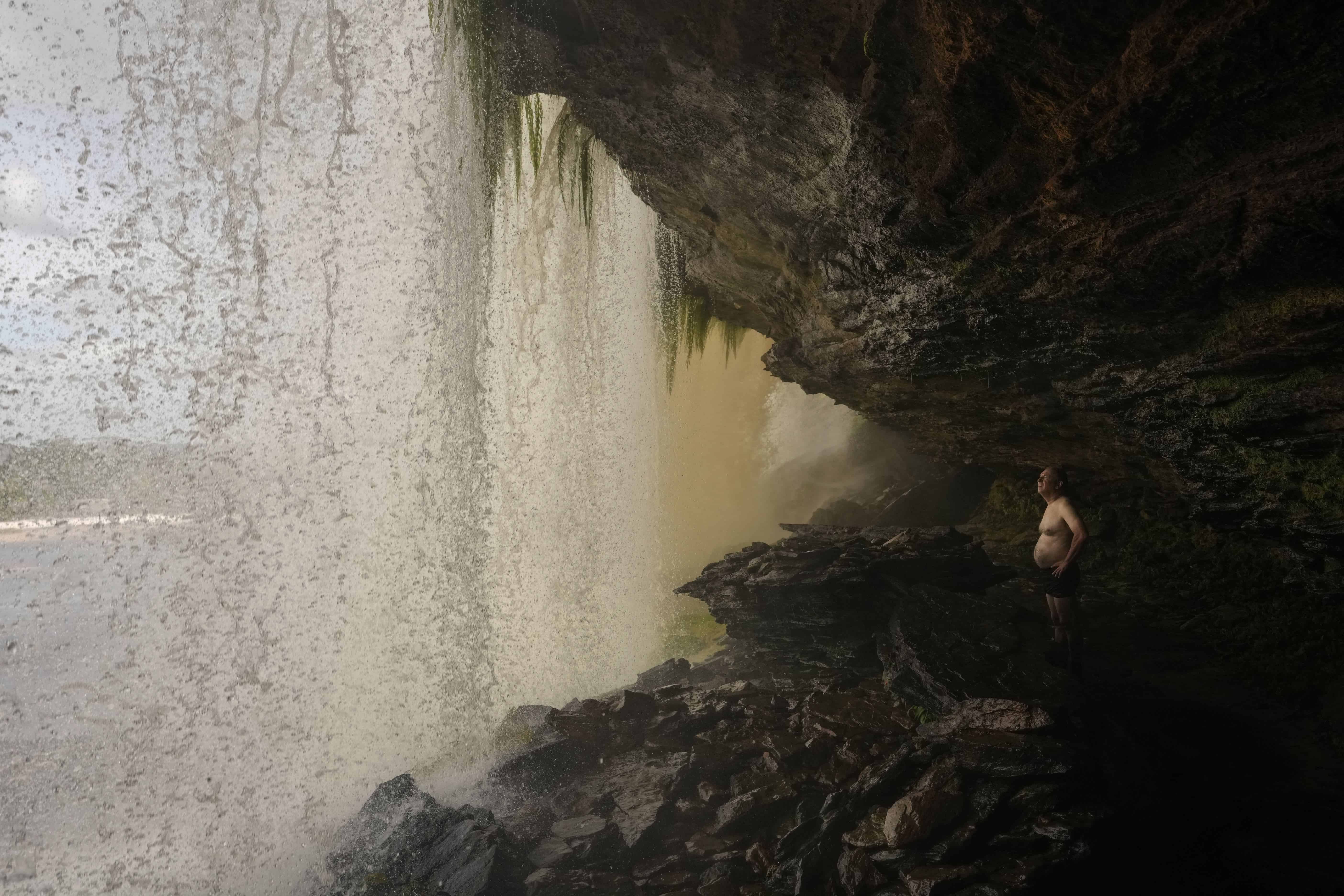 Un visitante observa desde debajo de la cascada Hacha en el Parque Nacional Canaima, Venezuela, 12 de enero de 2025.