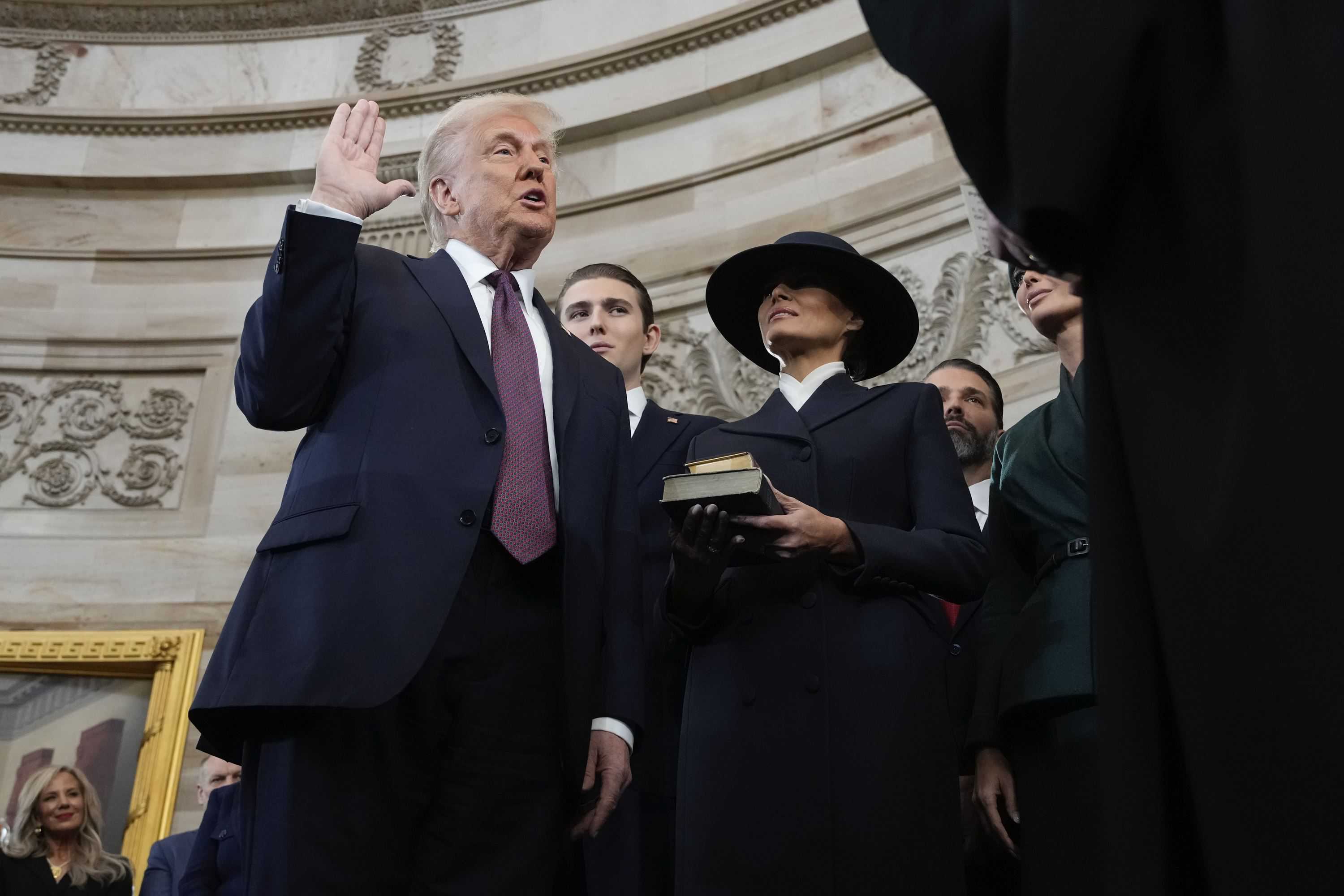 Donald Trump es juramentado como el 47o presidente de los Estados Unidos por el Presidente del Tribunal Supremo John Roberts mientras Melania Trump sostiene la Biblia durante la 60a Inauguración Presidencial en la Rotonda de los Estados Unidos. Capitolio en Washington, lunes 20 de enero de 2025.