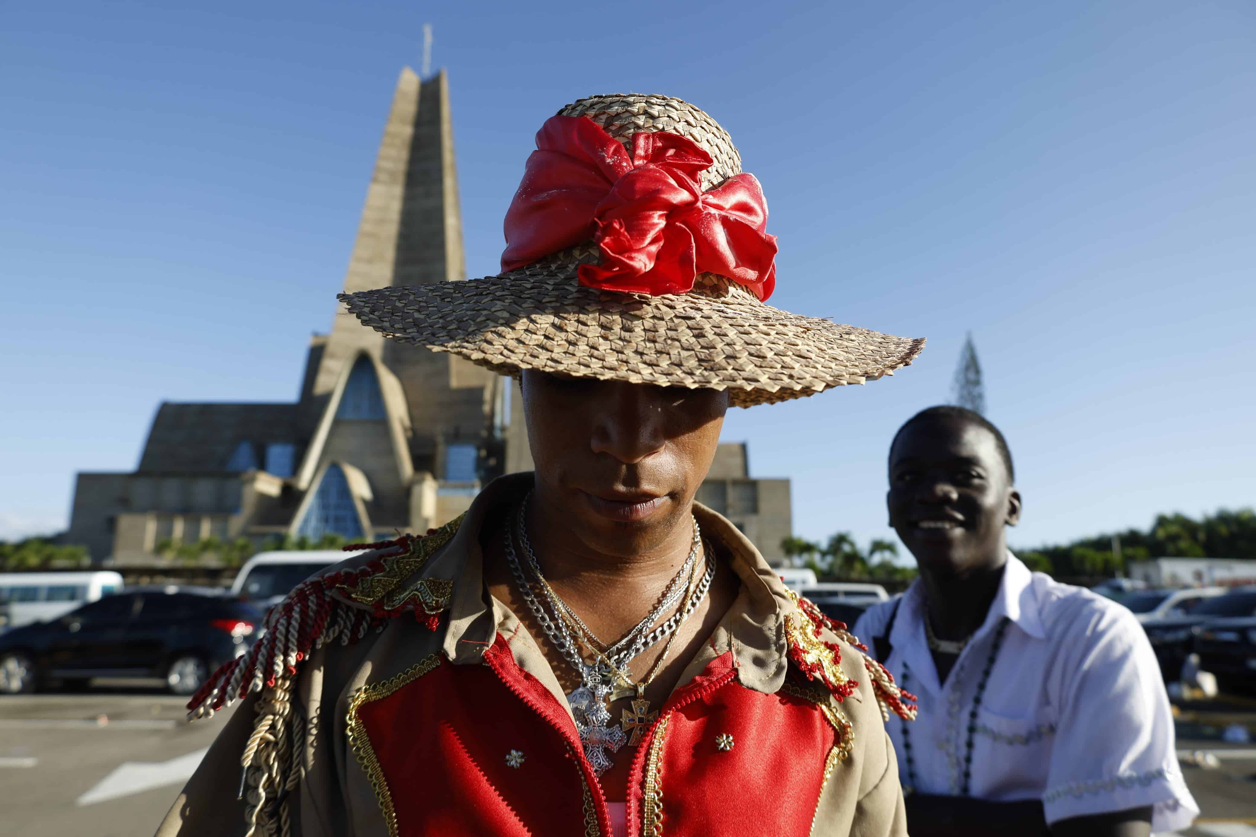 Vestido con los colores de Ogun Fegay, un hombre y sus acompañantes acuden a la Basilica de Higüey para cumplir un pacto con la Virgen de la Altagracia.