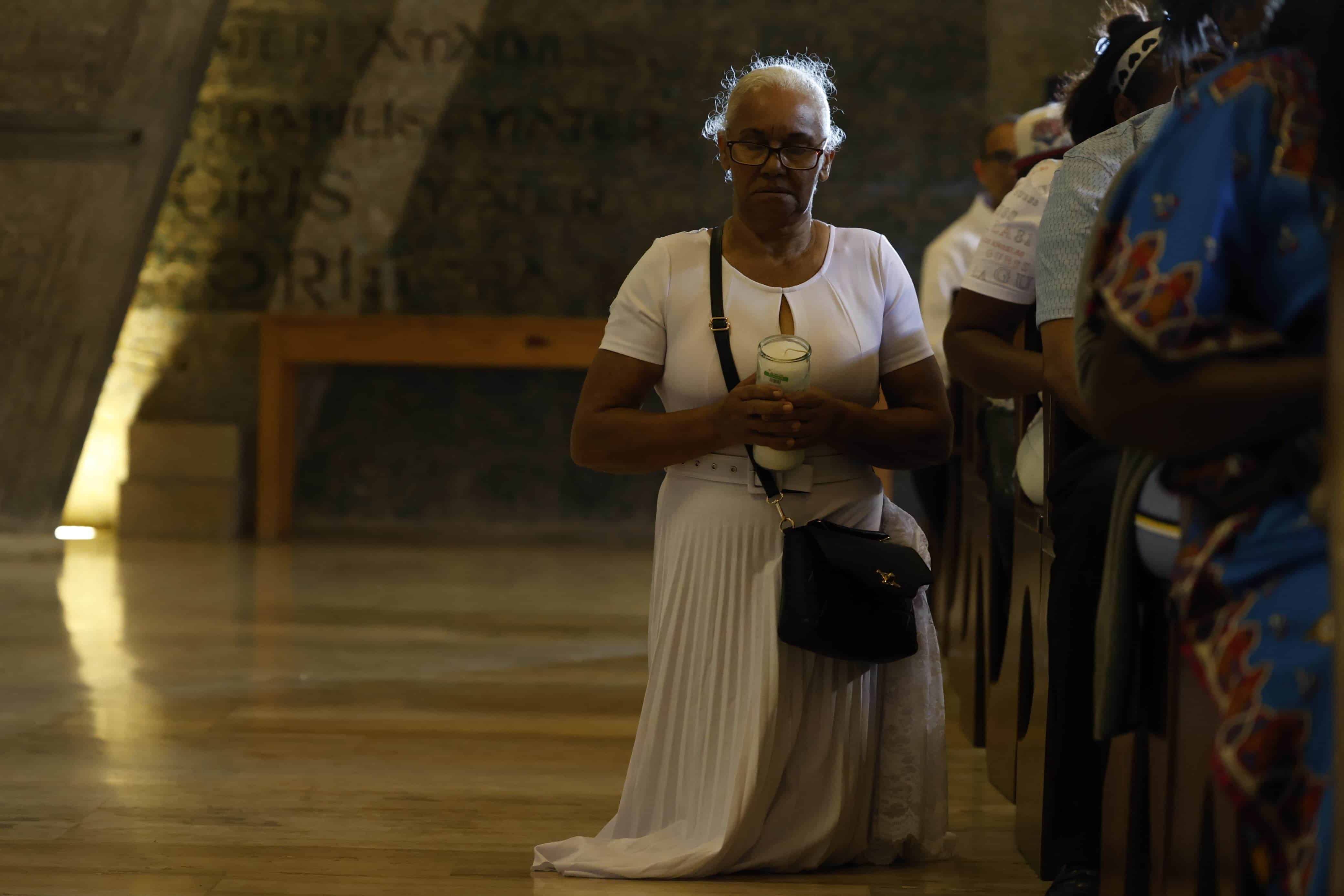 Una mujer, de rodillas, muestra su devoción por la Virgen de la Altagracia en el interior de la Basilica de Higüey.