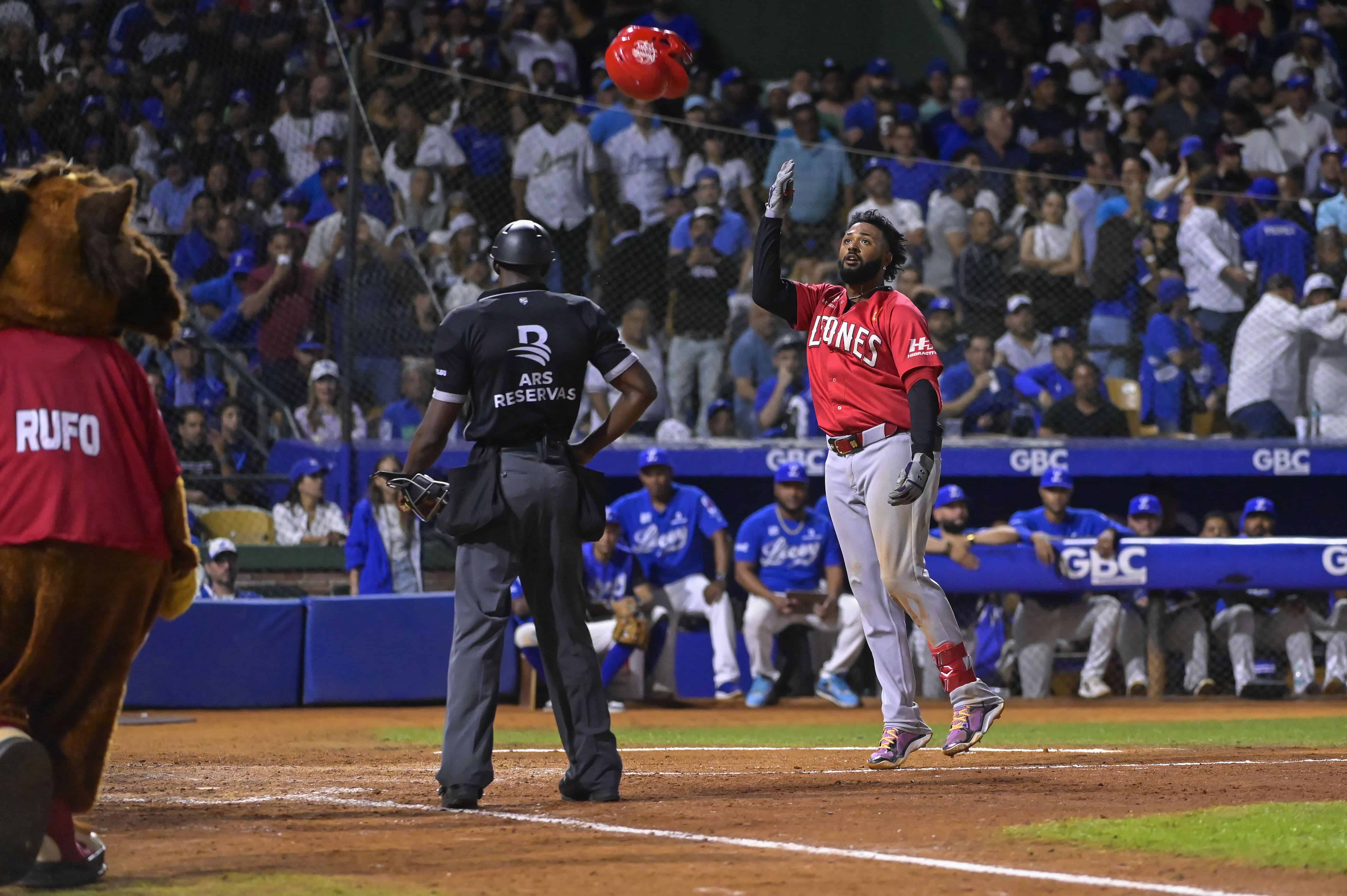 Junior Caminero, tira el casco al llegar al home plate, en señal de celebración por el jonrón que puso arriba a los Leones del Escogido con un marcador de 6 carreras por 5 ante los Tigres del Licey