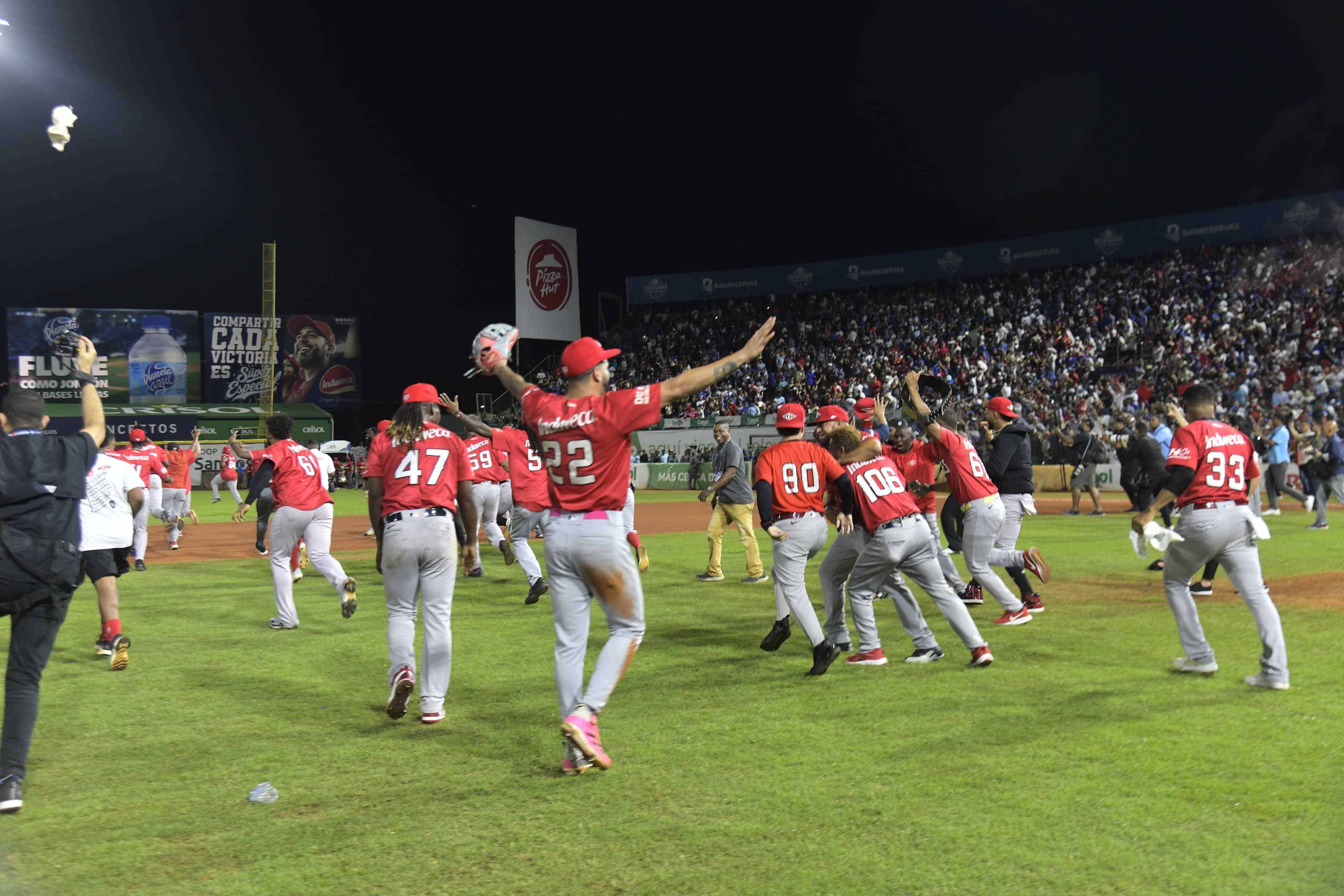 Jugadores del Escogido celebran en el terreno la corona 17.