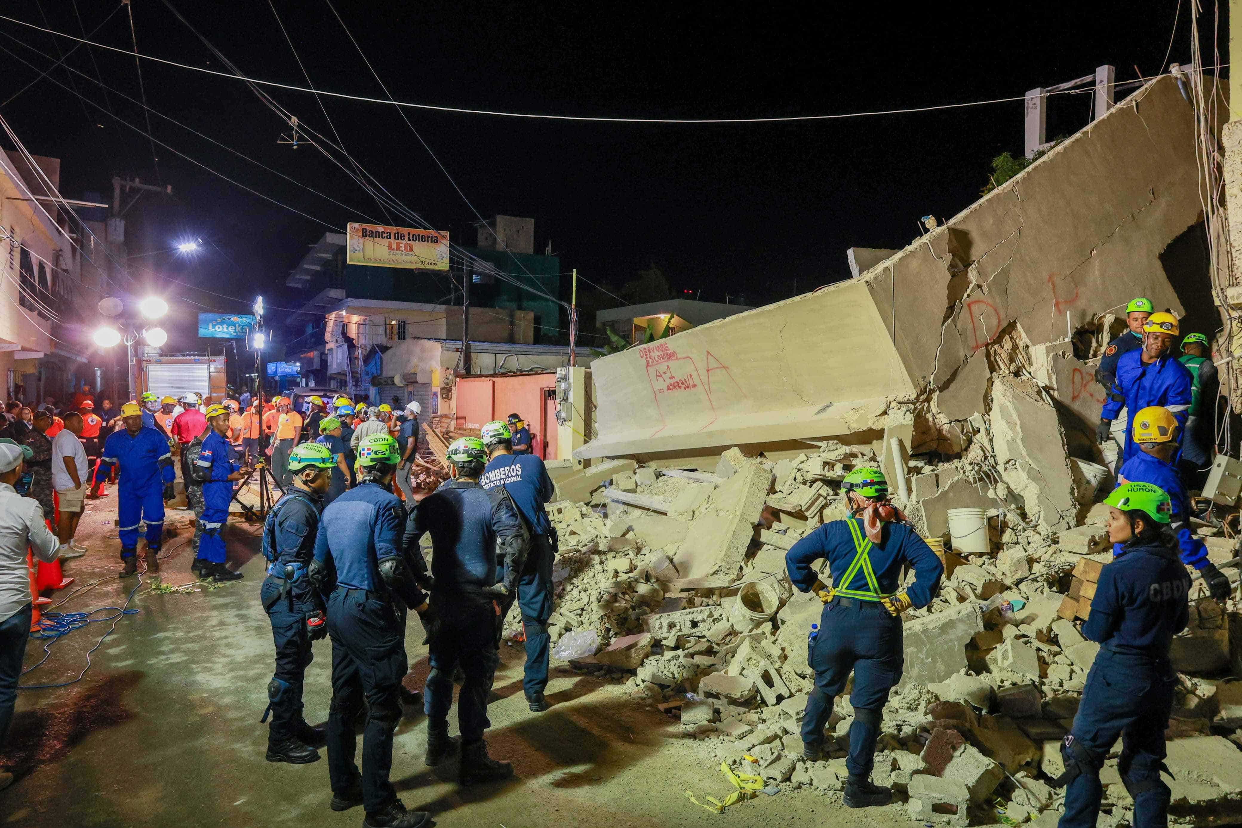 Miembros de cuerpos de rescate trabajan para recuperar víctimas del derrumbe.