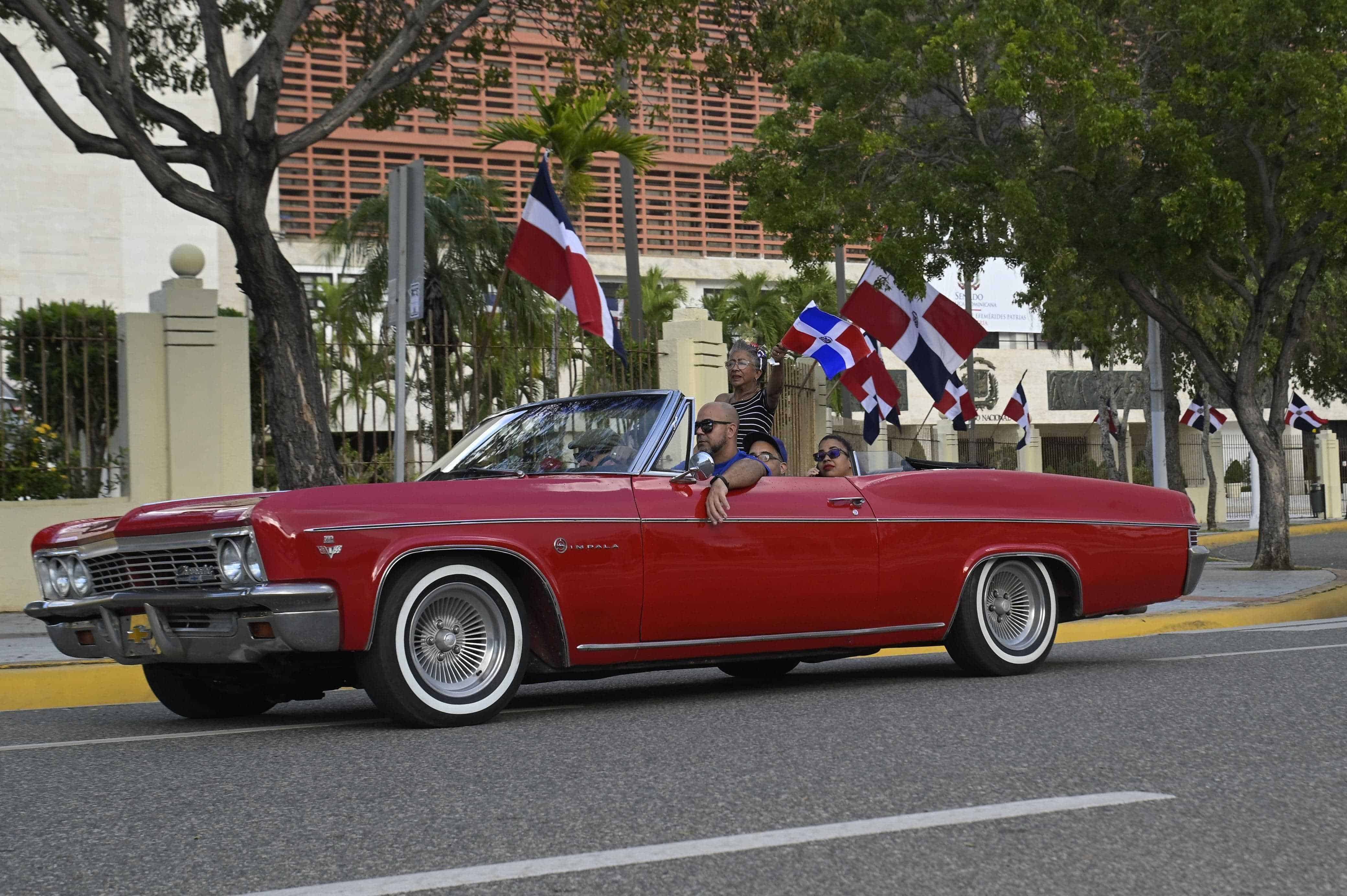 Una familia en un Crevrolet Impala desfila en honor a Duarte.