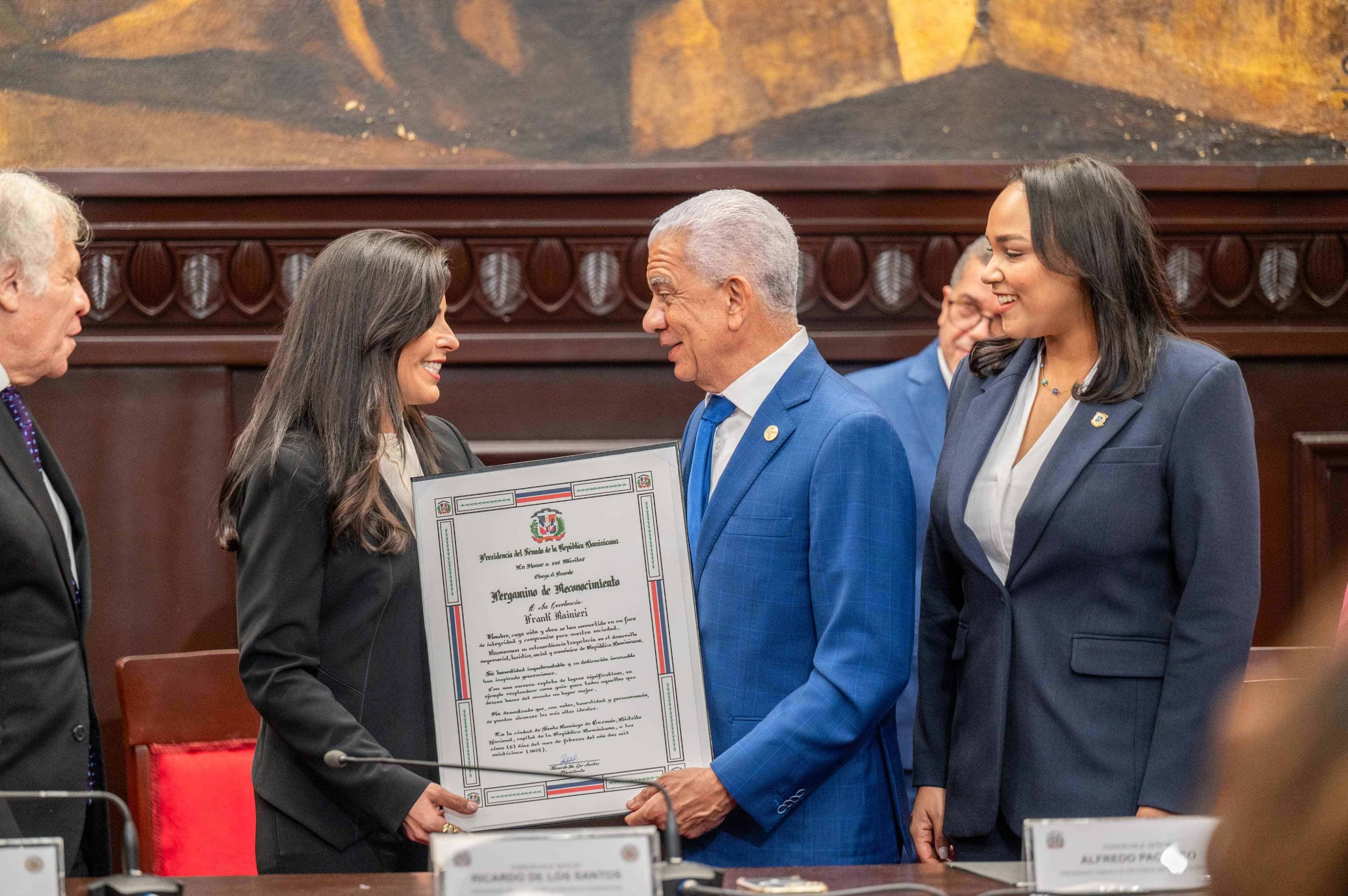 Francesca Rainieri recibe de manos del presidente del Senado, Ricardo de los Santos, el reconocimiento que esa cámara entregó a su padre Frank, Rainieri.