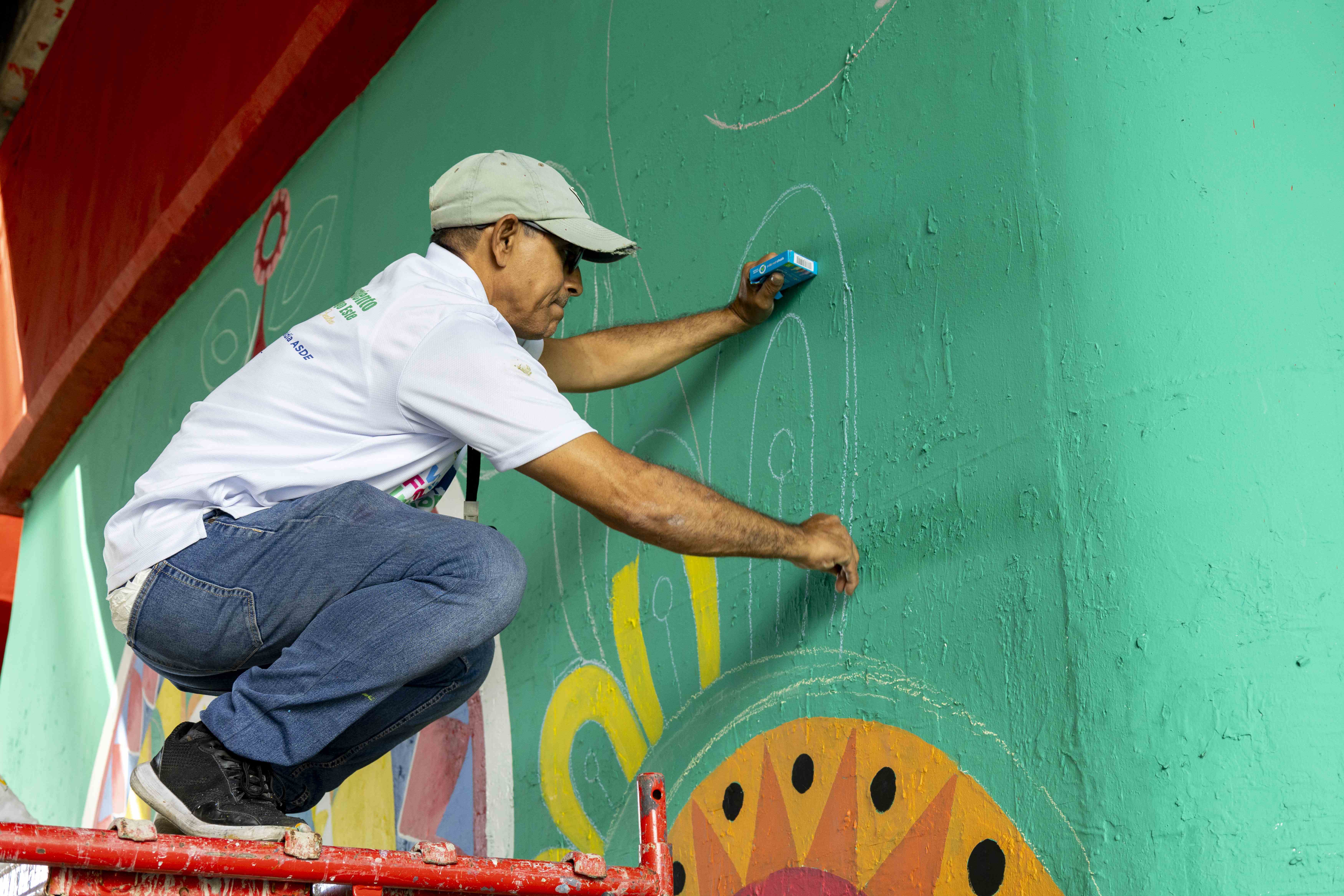 Artistas pintan un mural.