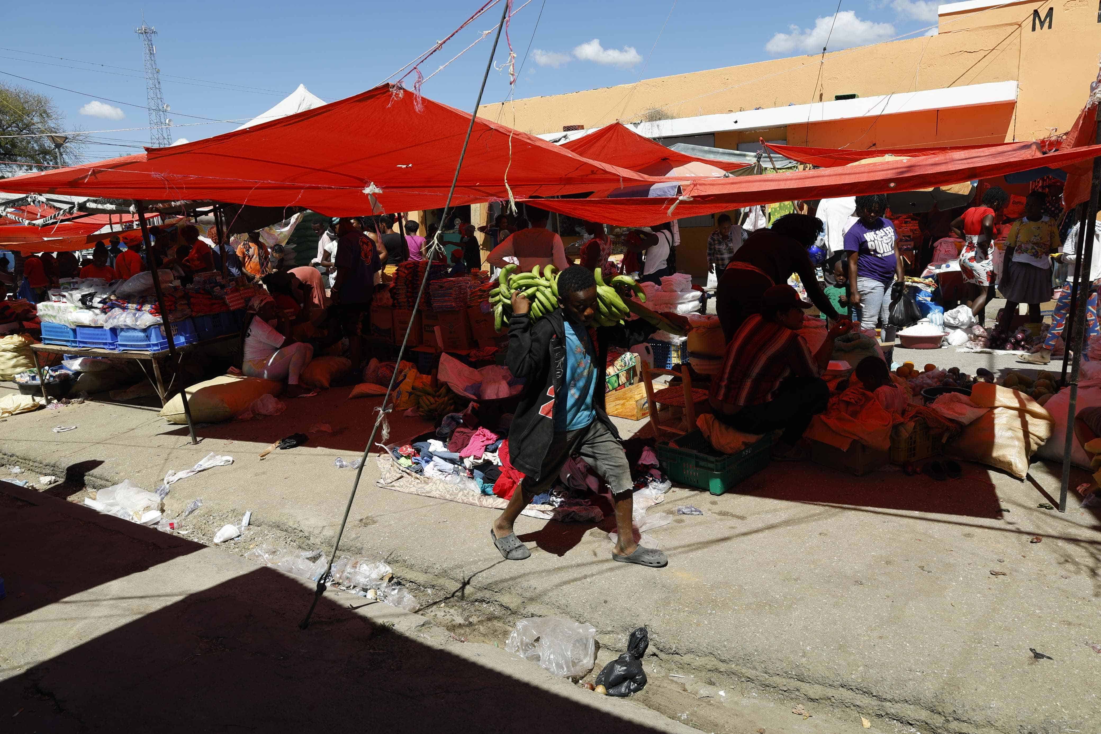 Un niño en el mercado binacional de Elías Piña cargando un racimo de plátanos. 