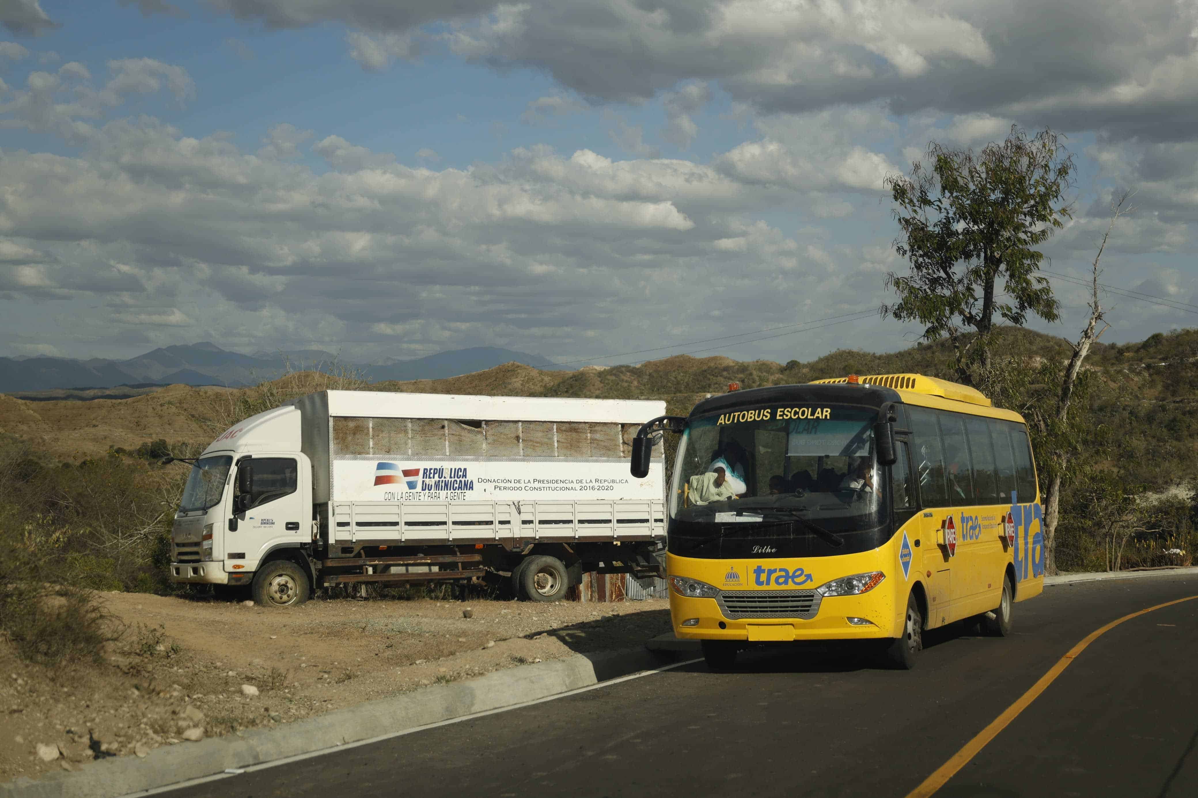 Vehículo abandonado del Gobierno, junto a un autobús del transporte escolar, mientras llevaba a los estudiantes al final de la carretera.