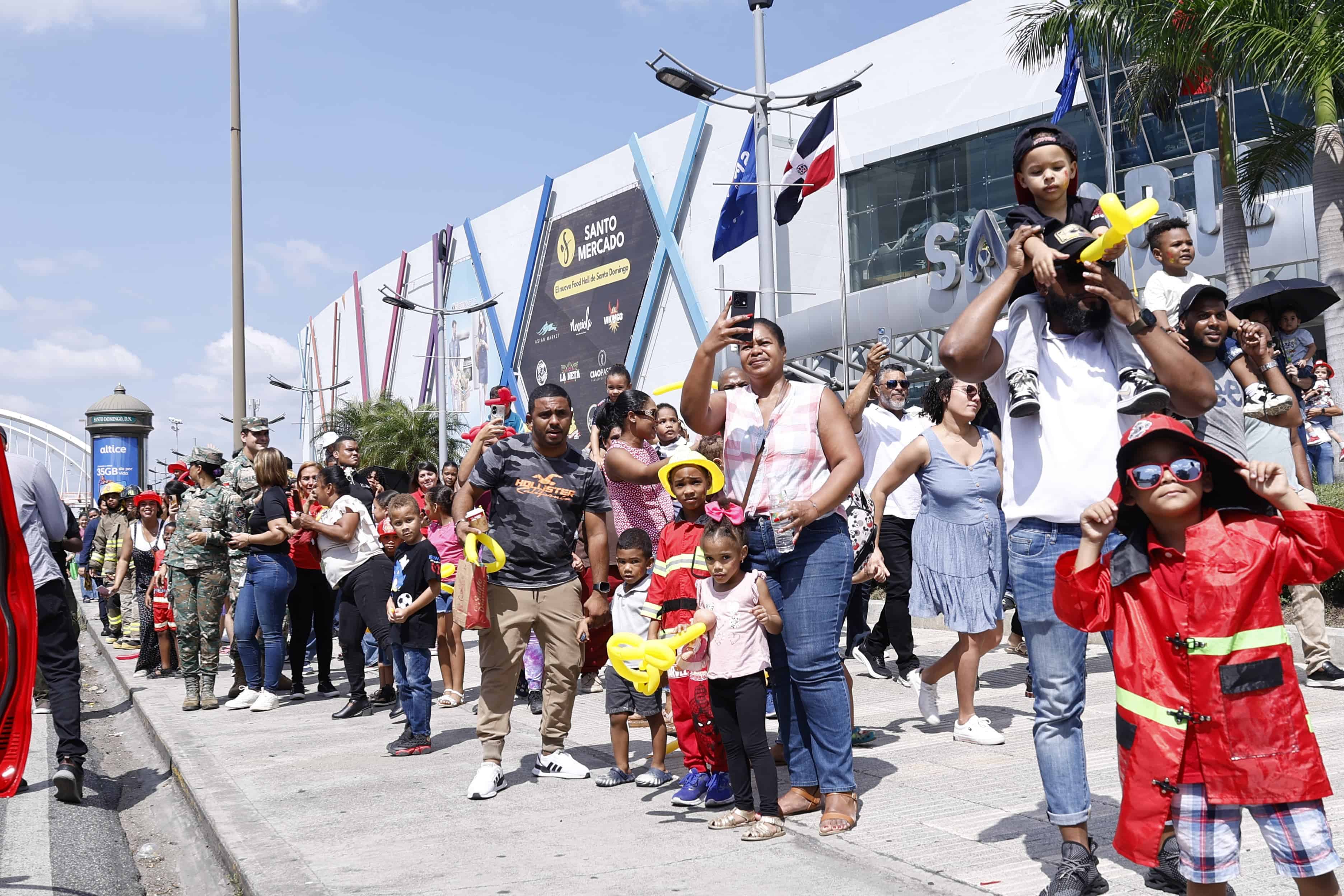 Decenas de niños y adultos se aglomeran en las afueras de Sambil para recibir la flotilla del Cuerpo de Bomberos.