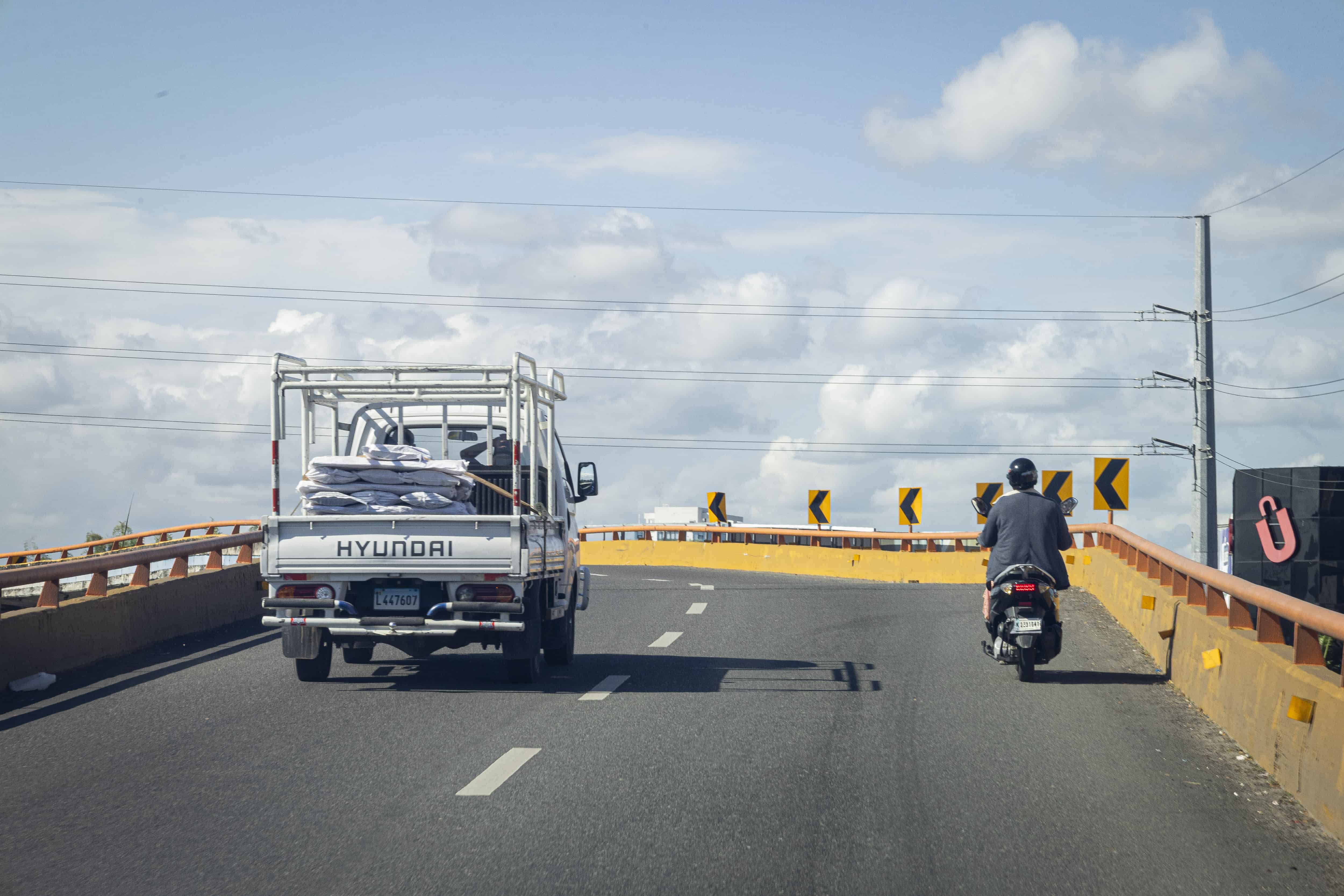 Mujer motorista, subiendo por el elevado.