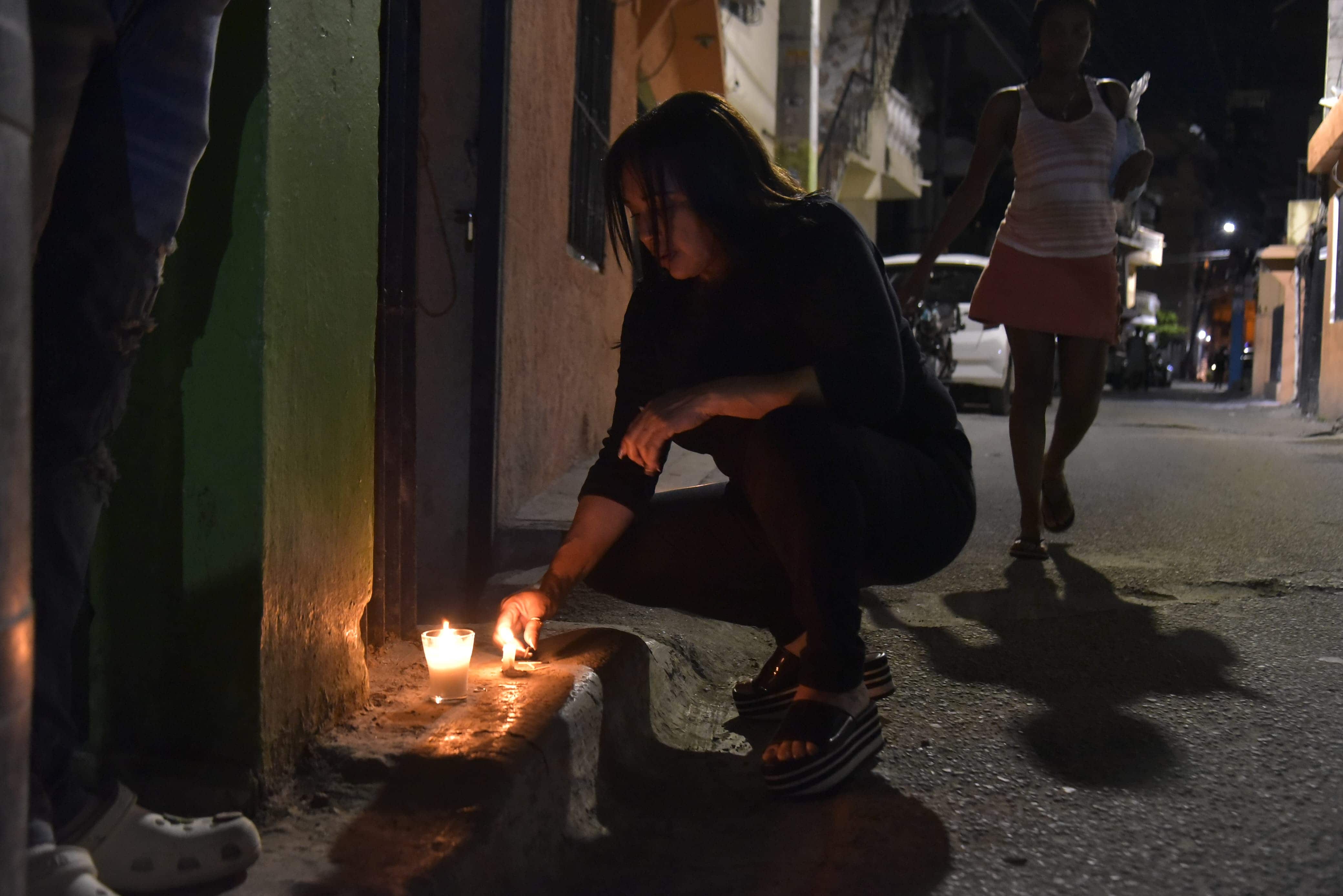 Otra personas con una vela por uno de los jóvenes asesinados en Herrera.