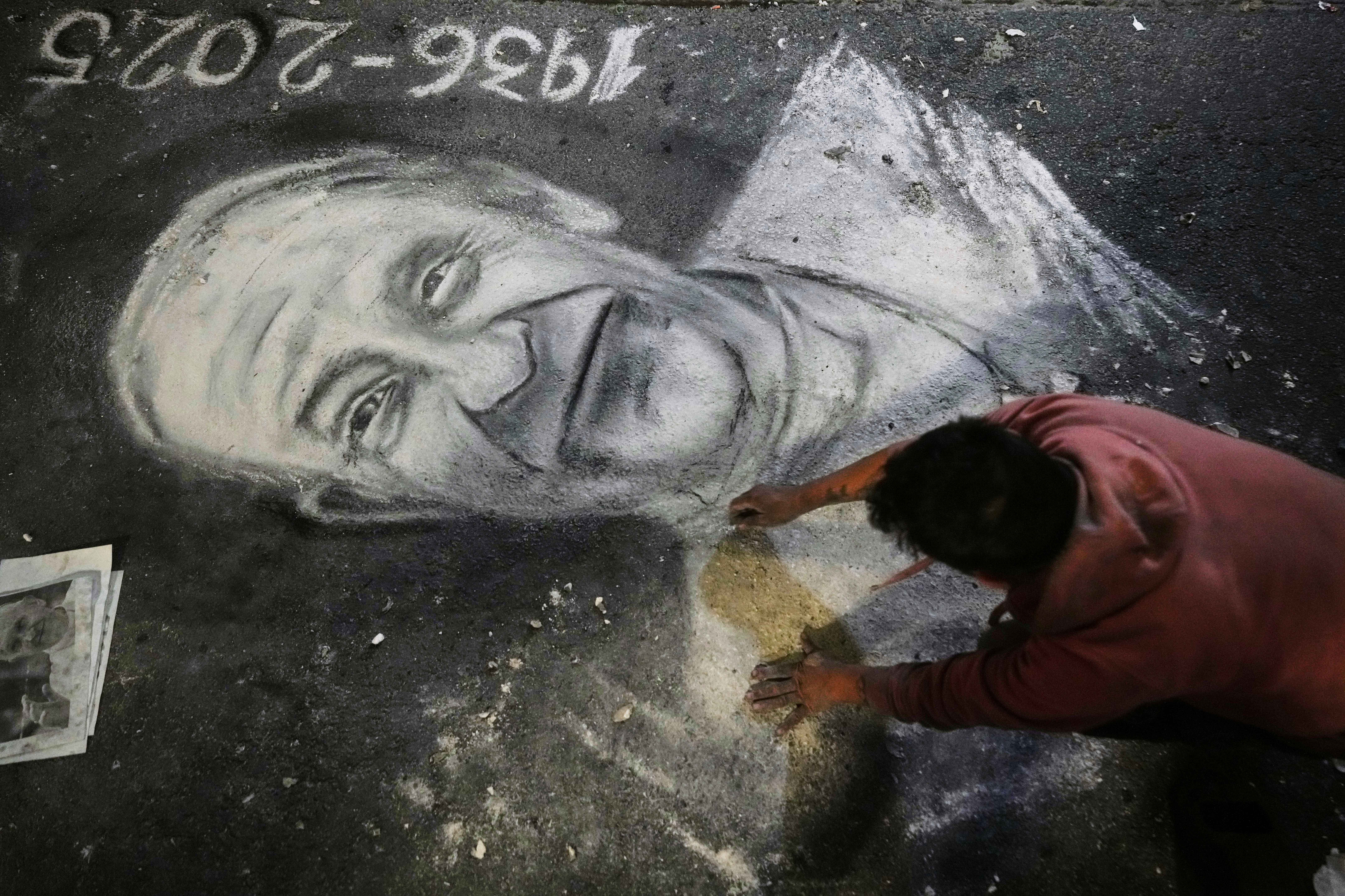 Un artista callejero dibuja con tiza un retrato del difunto Papa Francisco afuera de la Catedral de Buenos Aires, Argentina, el lunes 21 de abril de 2025.
