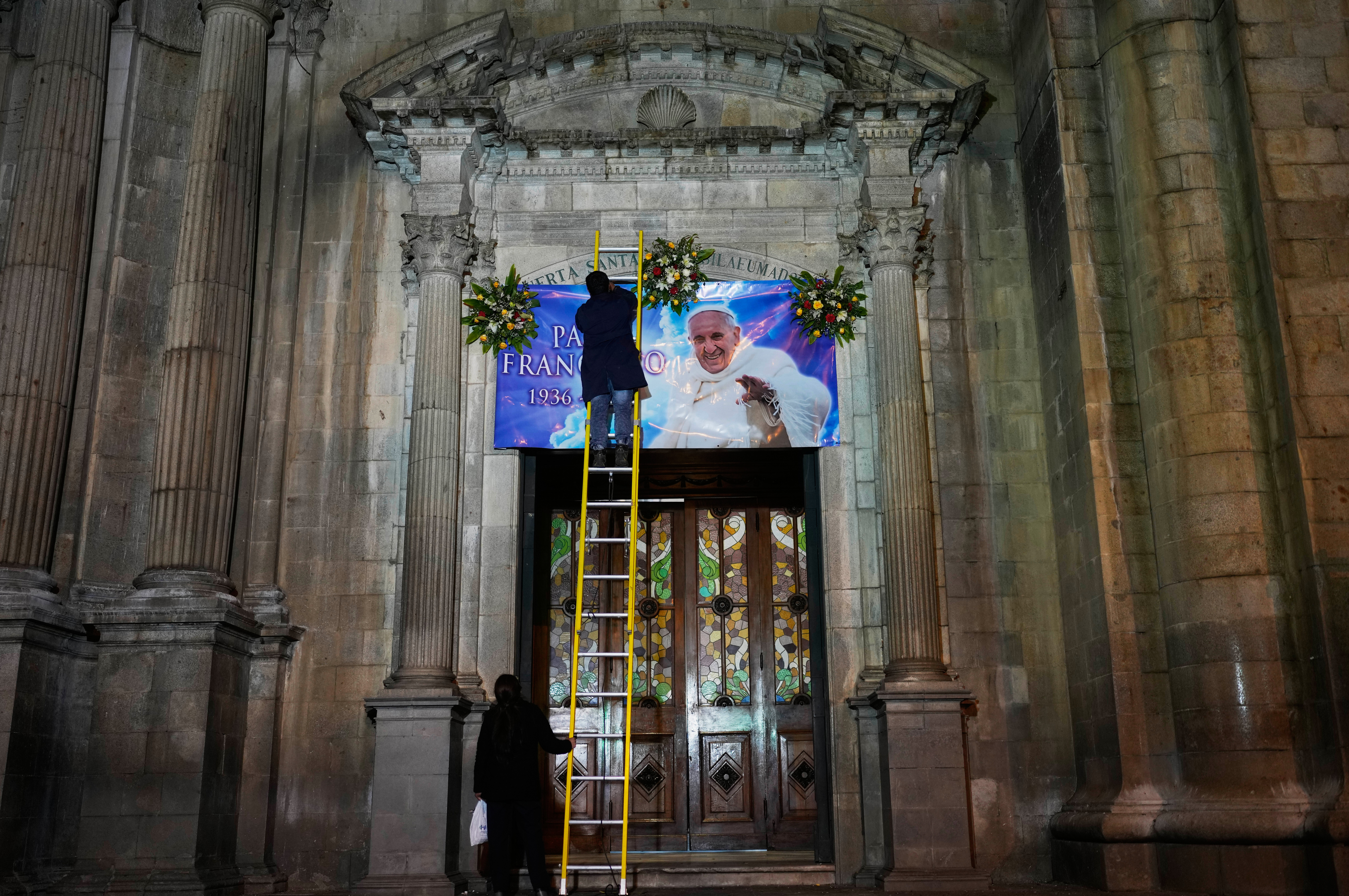 Un trabajador coloca una pancarta del fallecido Papa Francisco en el frente de la Catedral Nuestra Señora de La Paz, Bolivia, el lunes 21 de abril de 2025.