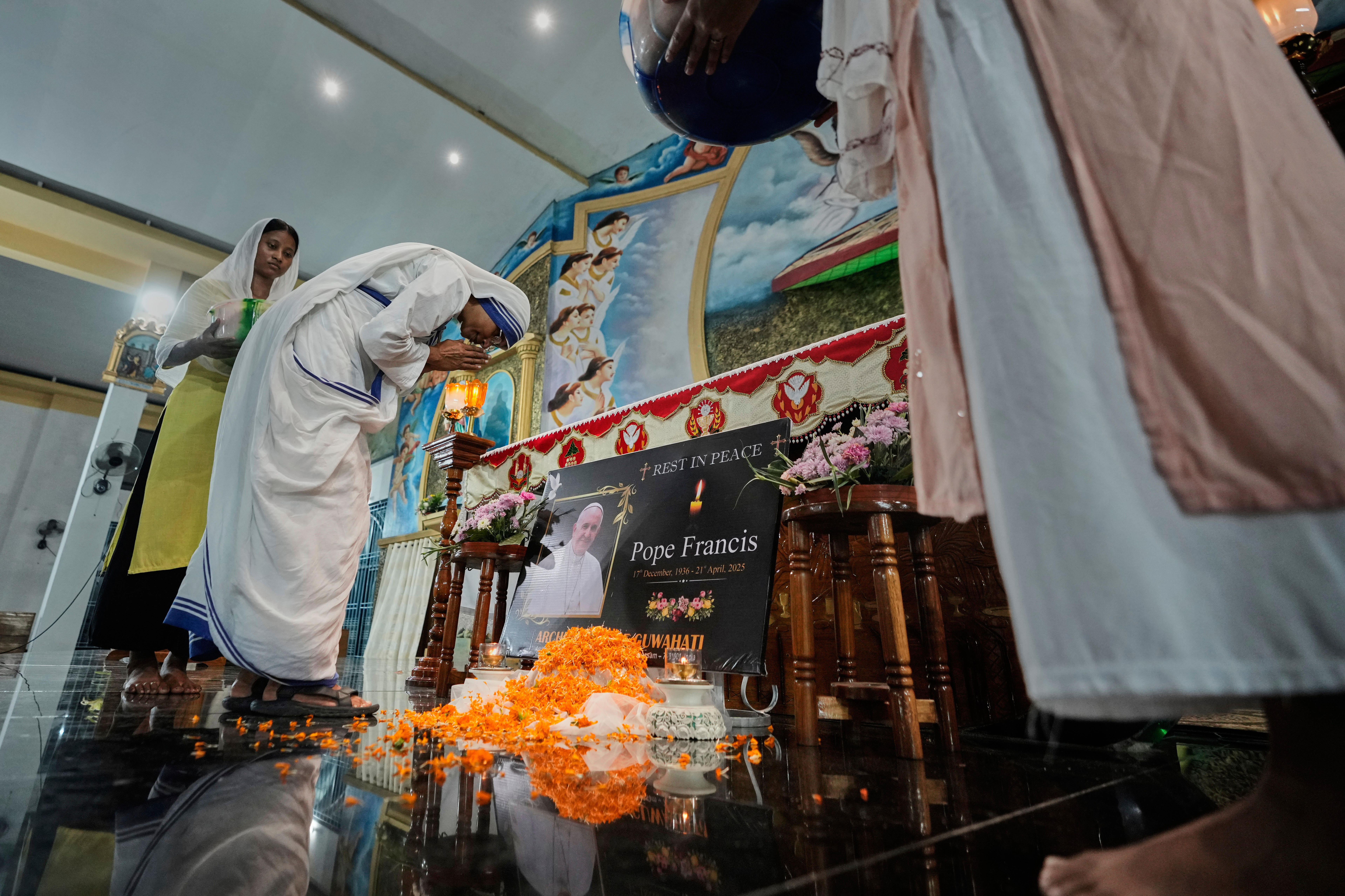 Un retrato del difunto Papa Francisco aparece frente al altar durante una misa de réquiem en una iglesia en Guwahati, India, el martes 22 de abril de 2025.