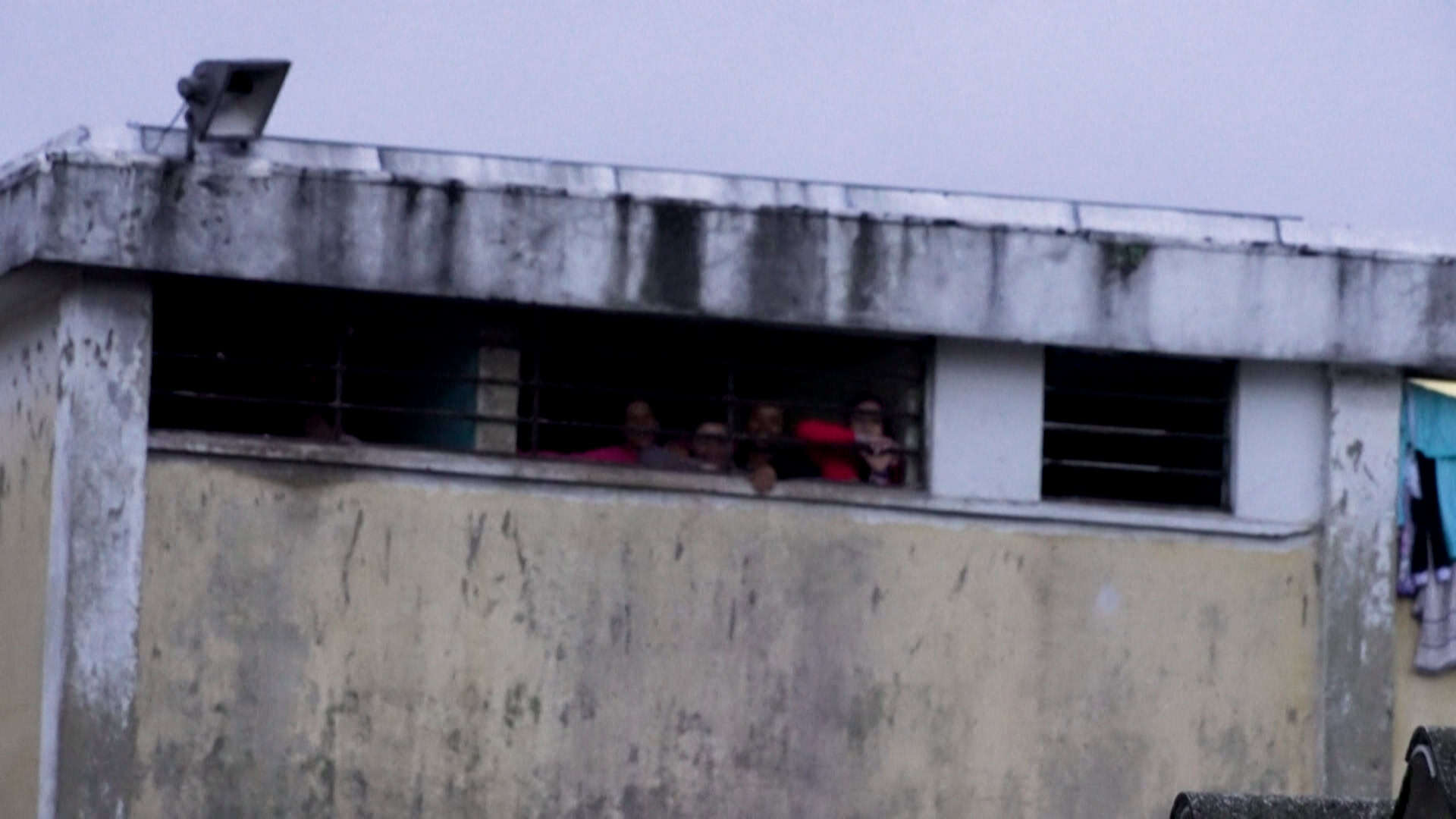 Reclusas miran por la ventana de la cárcel  El Buen Pastor, en Bogotá el 29 de abril de 2025.