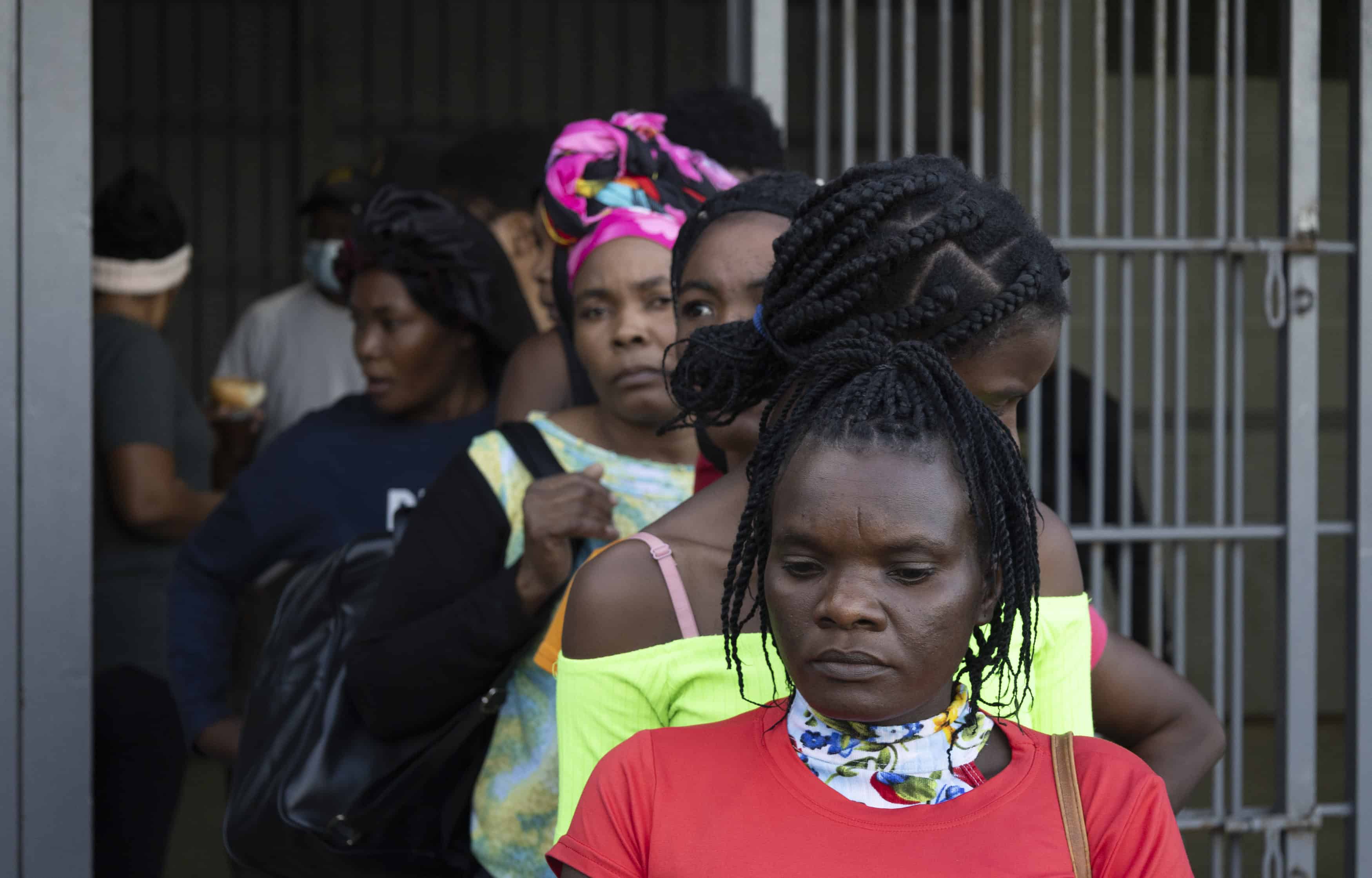 Mujeres y niños haitianos, haciendo fila antes de su deportación.