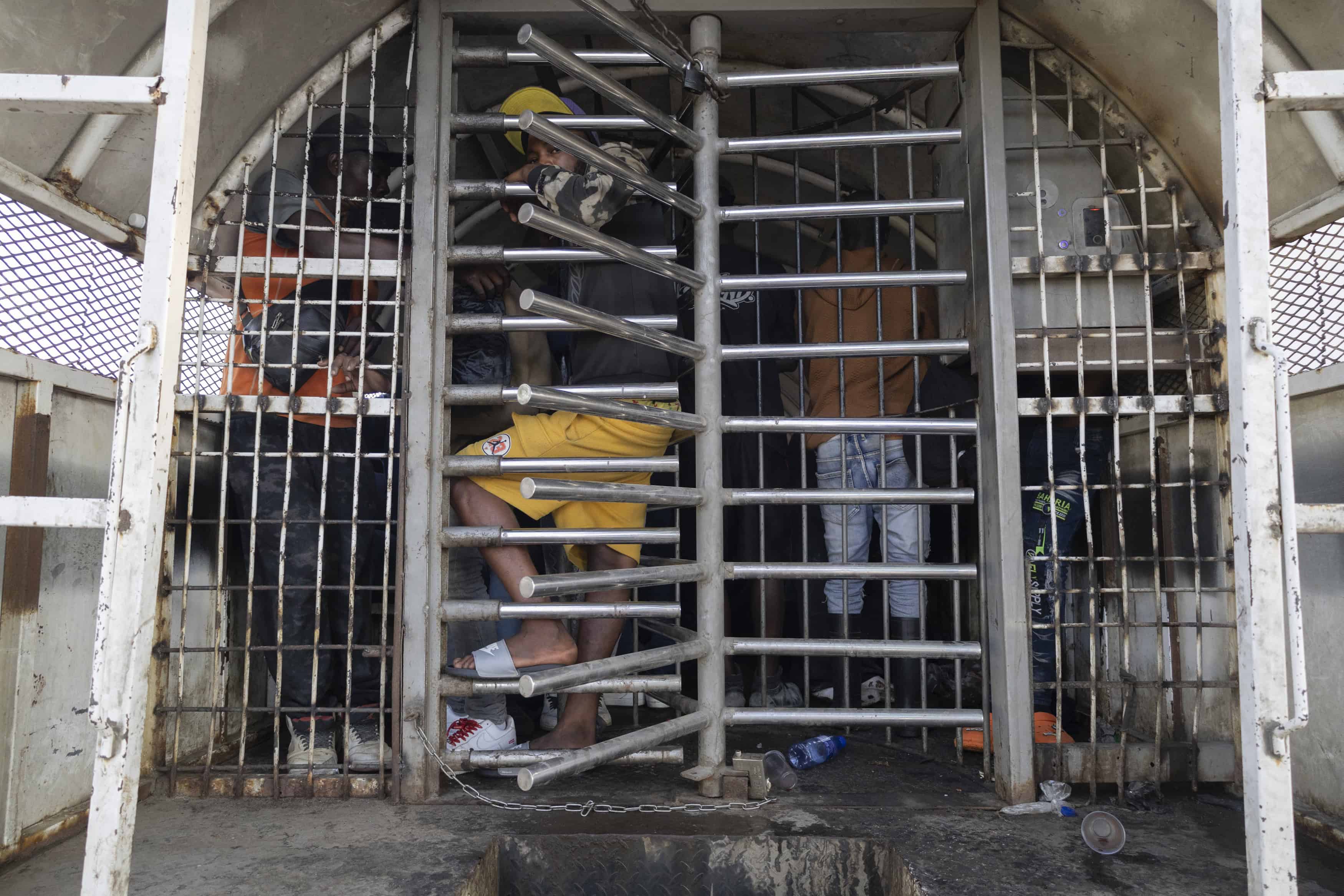 Hombres haitianos, de pie y sentados dentro del camión lleno.