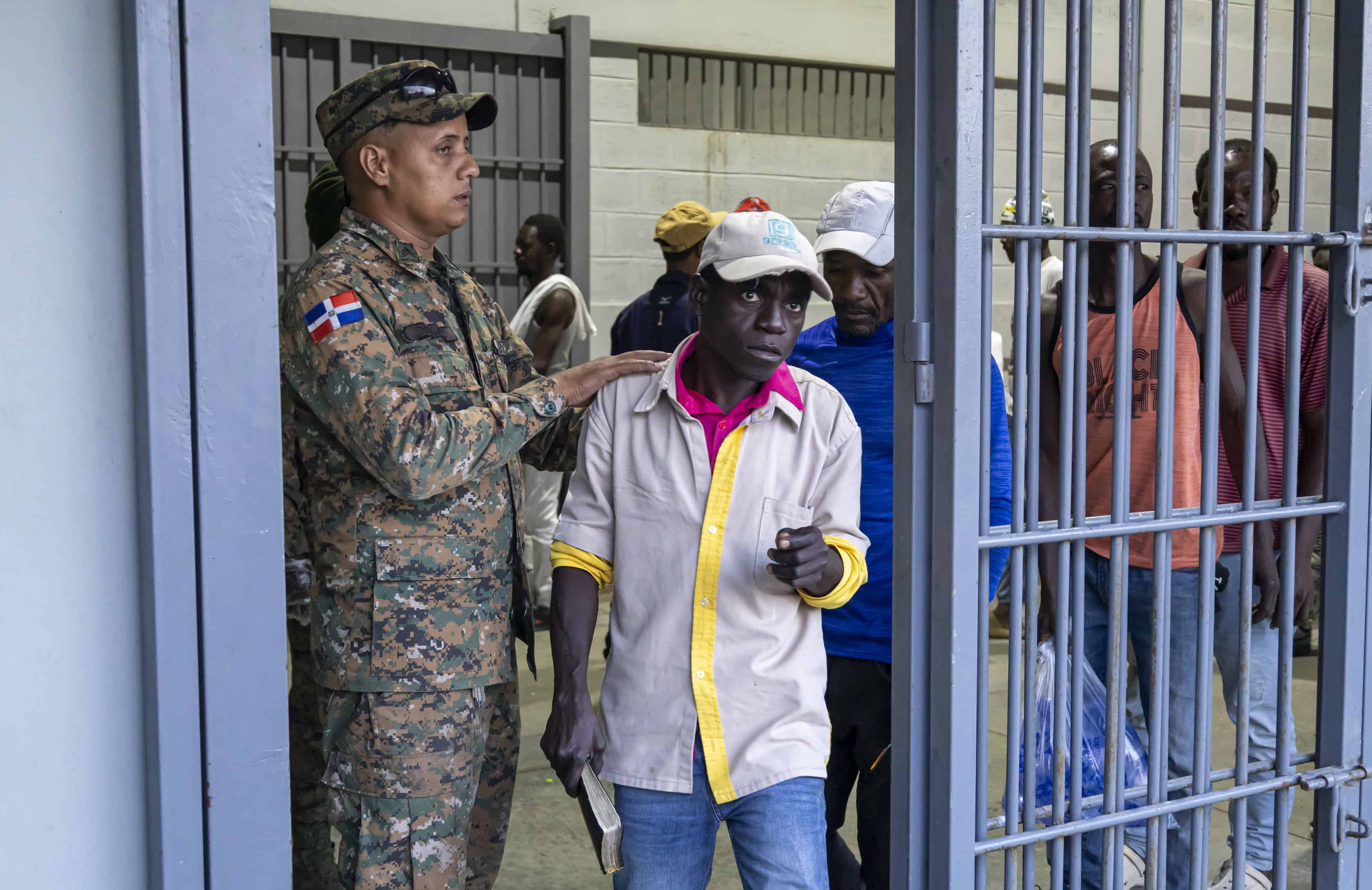 Los hombres haitianos empiezan a salir para entrar al camión.