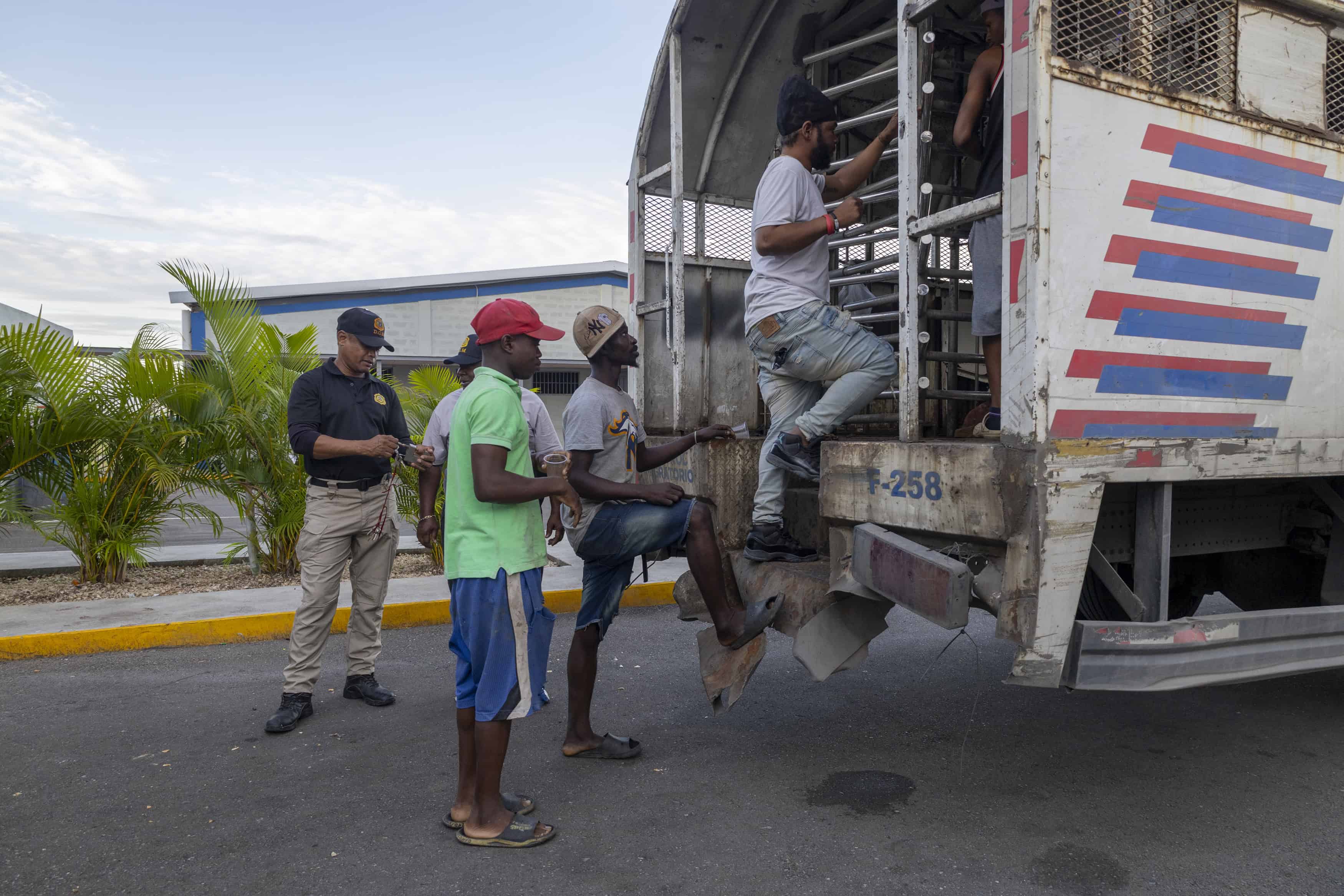 Fila de haitianos entrando en el camión de Migración.