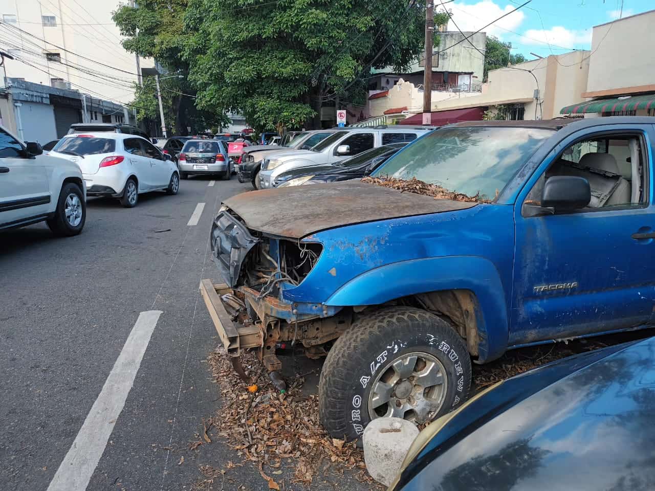 Una camioneta azul, abandonada en la zona de Gascue, con un cúmulo de desechos a su alrededor.