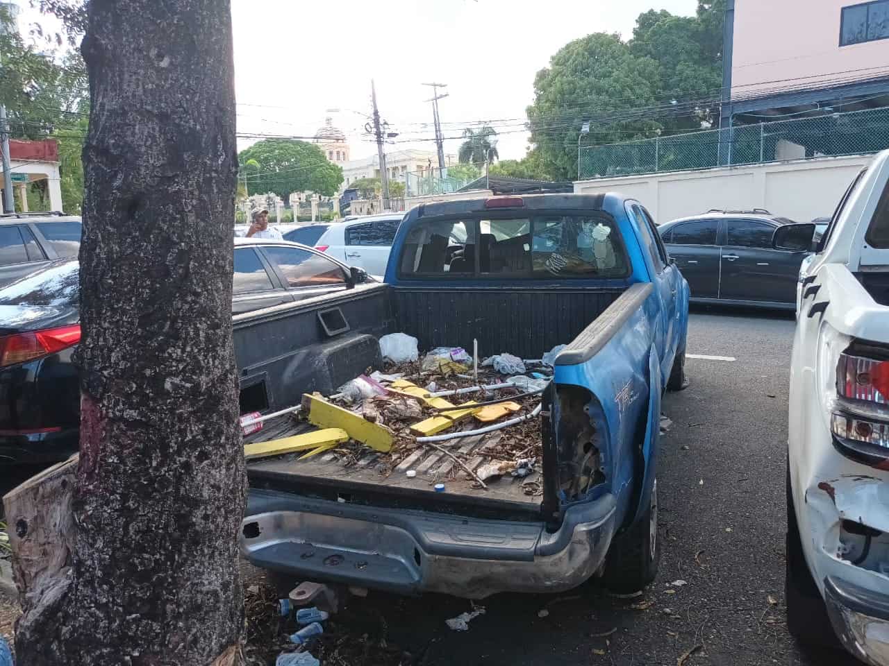 La parte trasera de la camioneta azul con basura.
