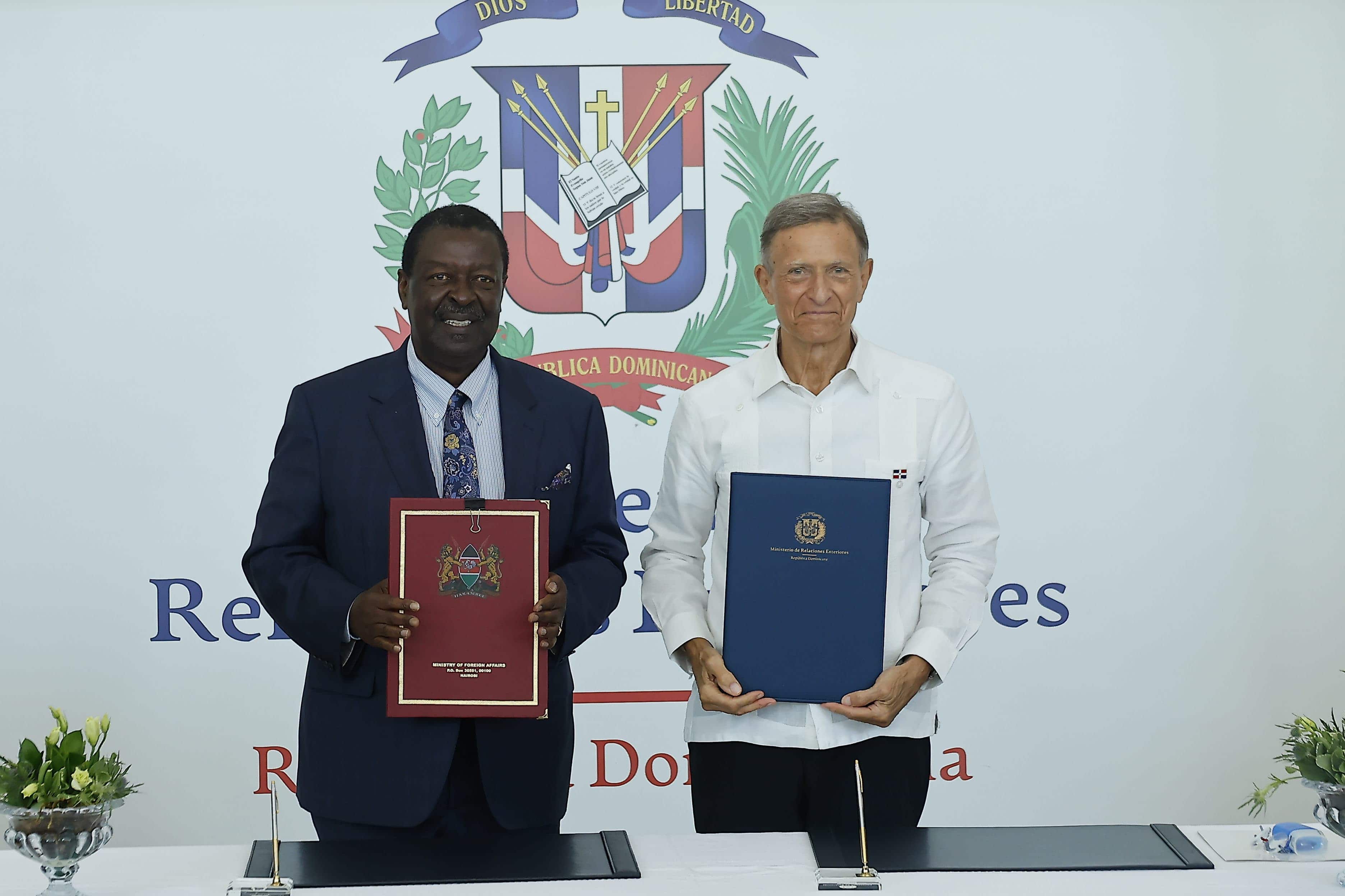 El canciller dominicano, Roberto Álvarez, y su homólogo de Kenia, Musalia Mudavadi, posan con los convenios firmados este lunes 12 de mayo del 2025, durante un acto celebrado en el Centro de Convenciones del Ministerio de Relaciones Exteriores.<br>