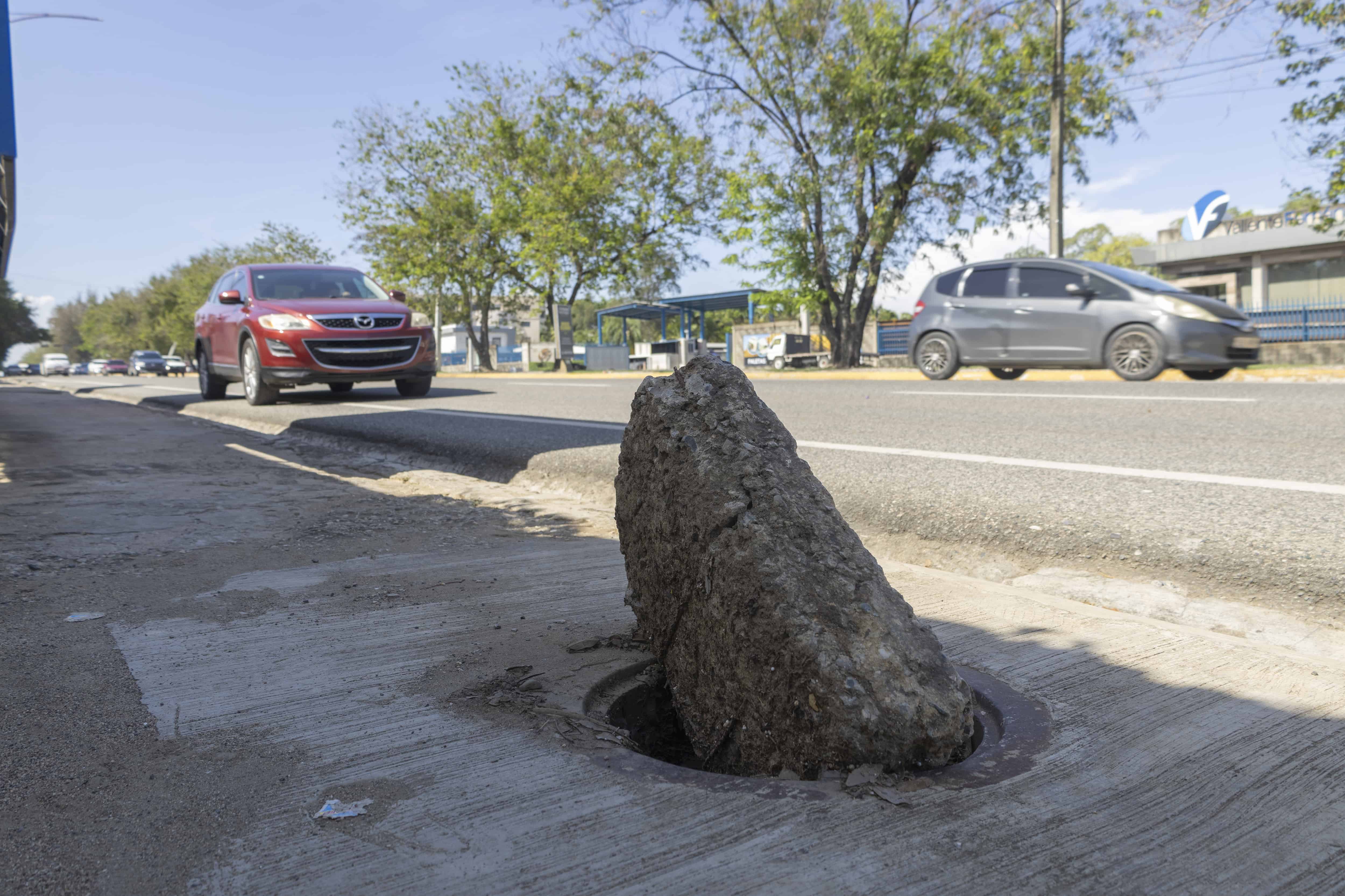 Una piedra grande tapando un hoyo de alcantarilla.