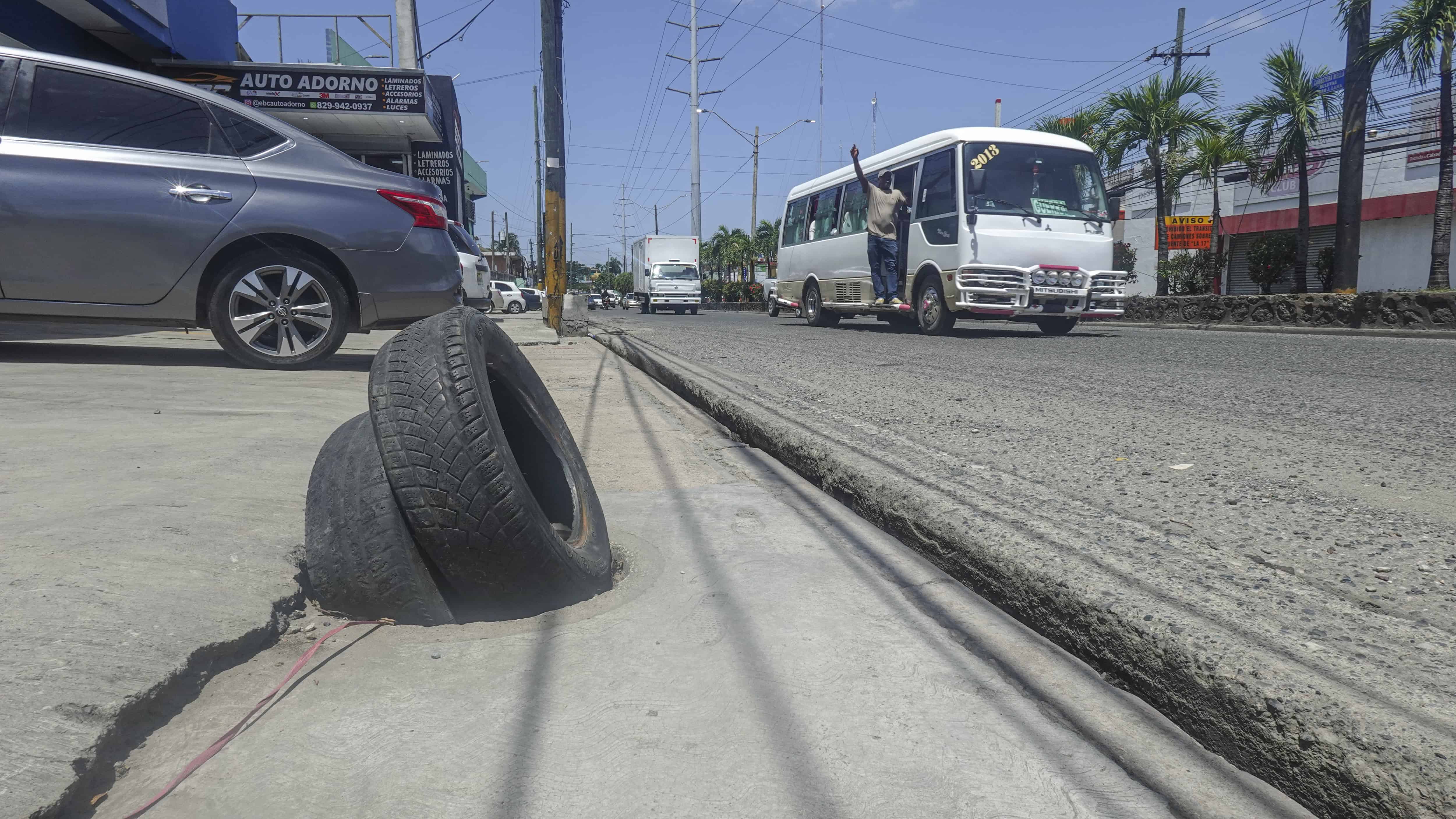 Neumáticos tapando un hoyo de alcantarilla.