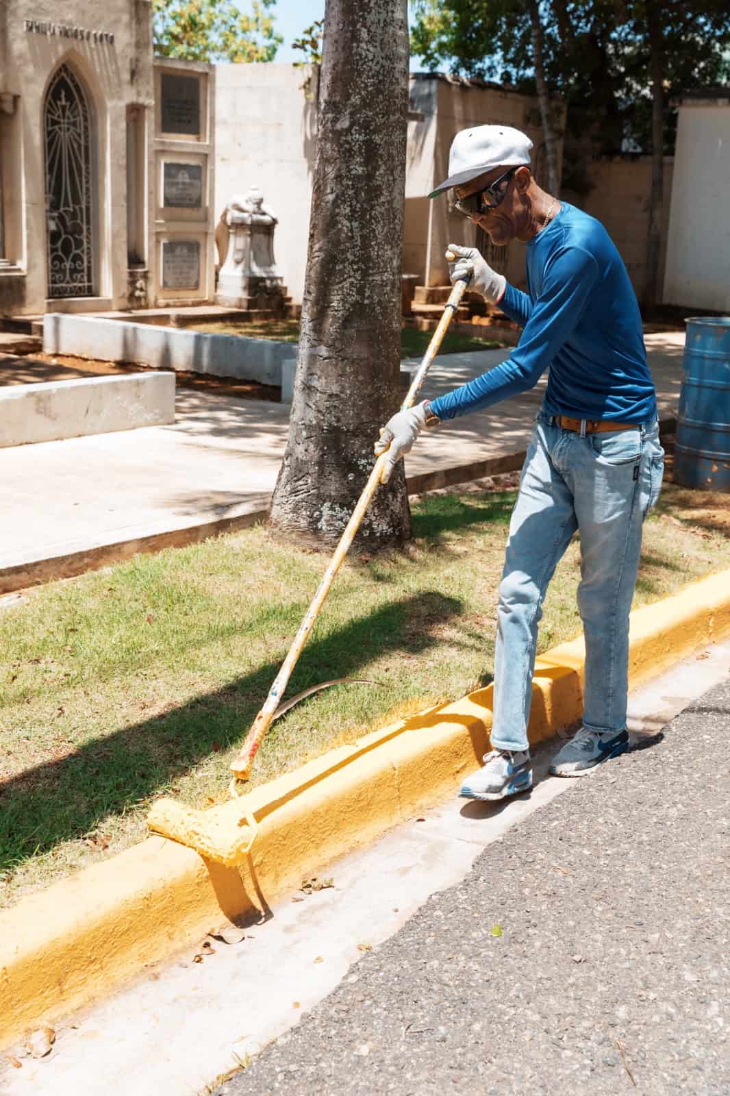 Un obrero de la Alcaldía del Distrito Nacional pintan los contenes del Cementerio Nacional.