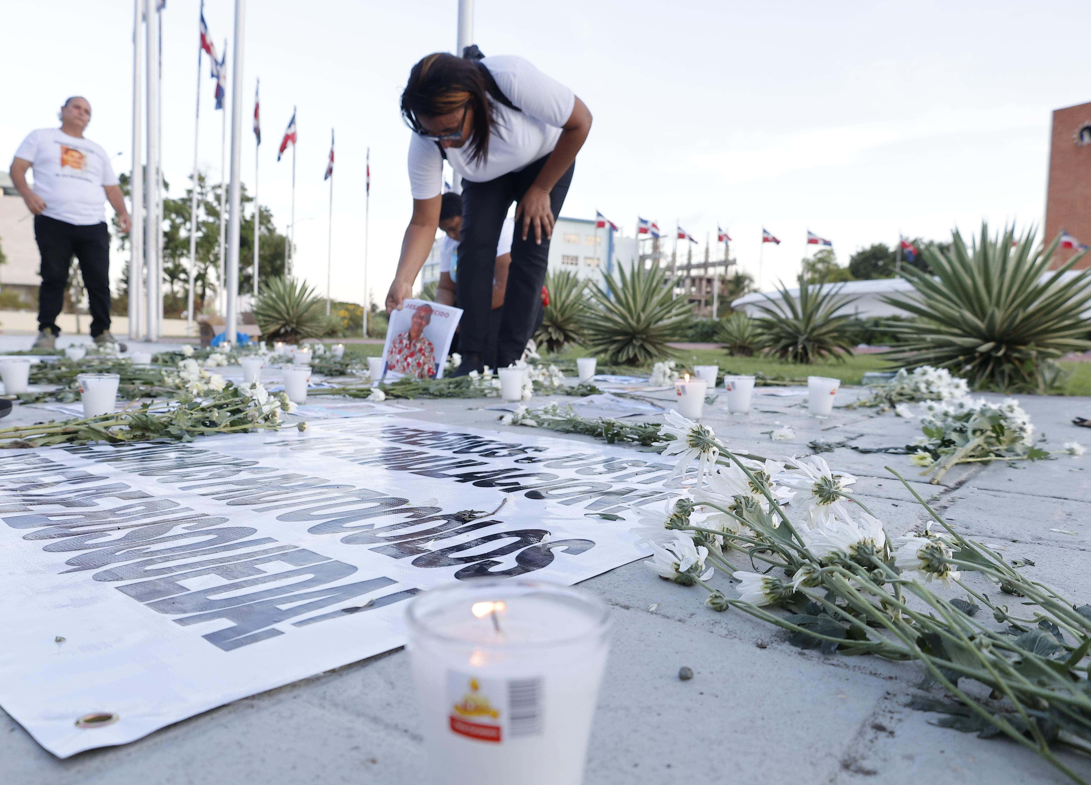 Familiares colocan velas encendidas, flores y fotografías de sus parientes desaparecidos este viernes 23 de mayo frente al Congreso Nacional en Santo Domingo. 