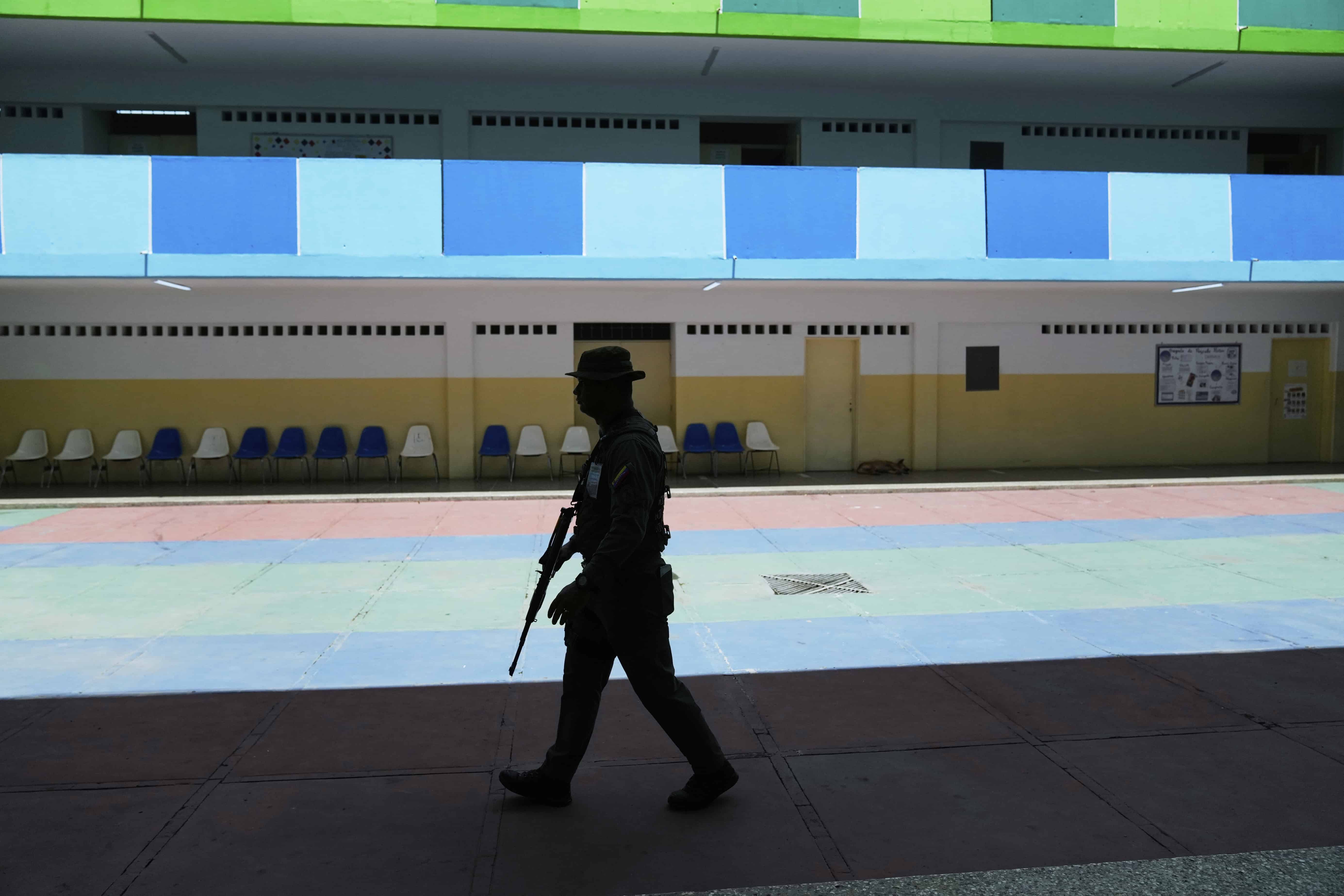 La Guardia Nacional camina en un colegio electoral desierto durante las elecciones legislativas y locales en Caracas, Venezuela, el domingo 25 de mayo de 2025. 