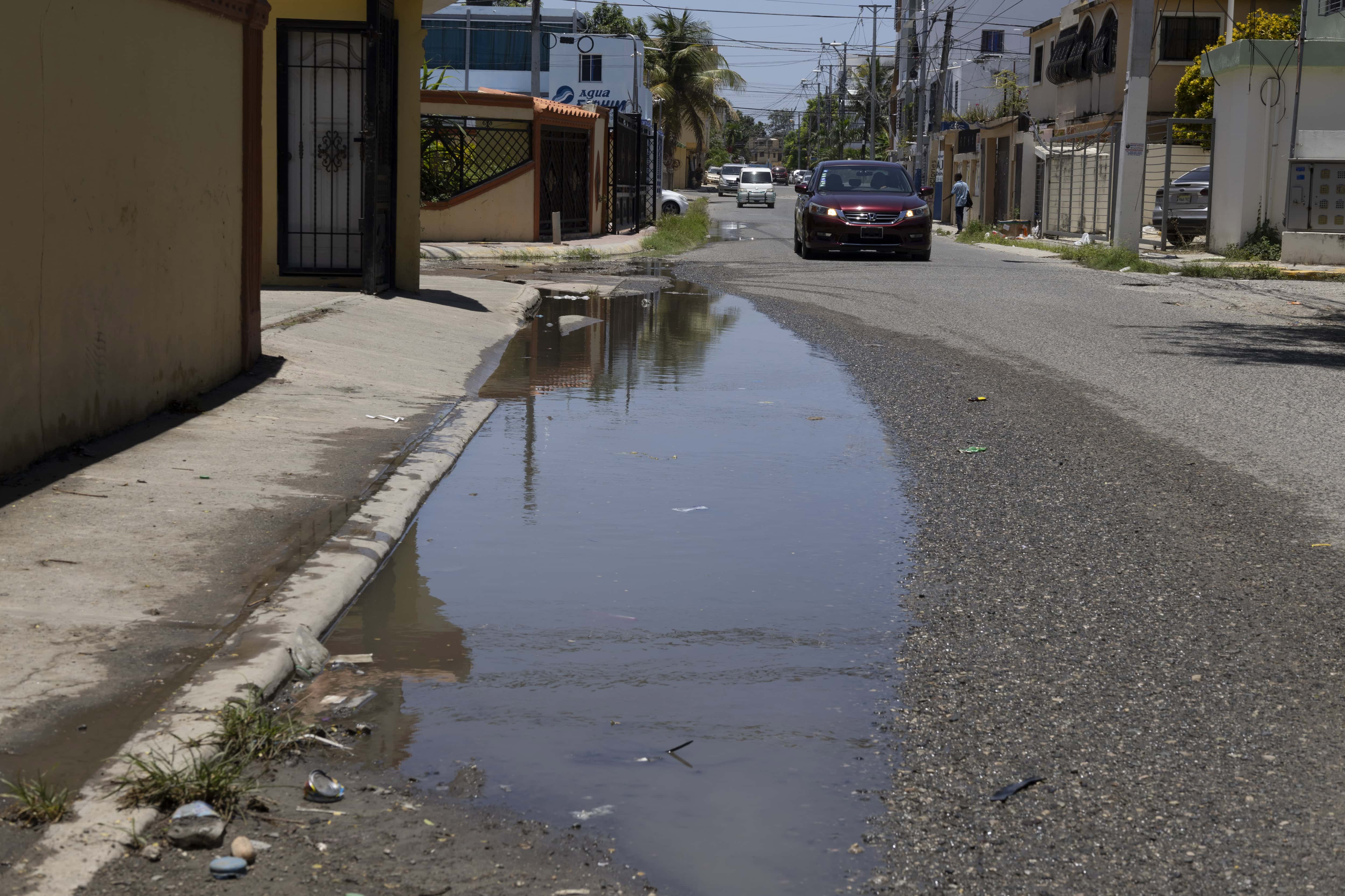 Las aguas todavía se acumulan en las calles con baches producto de la lluvia en Arismar, Los Frailes, SDE.