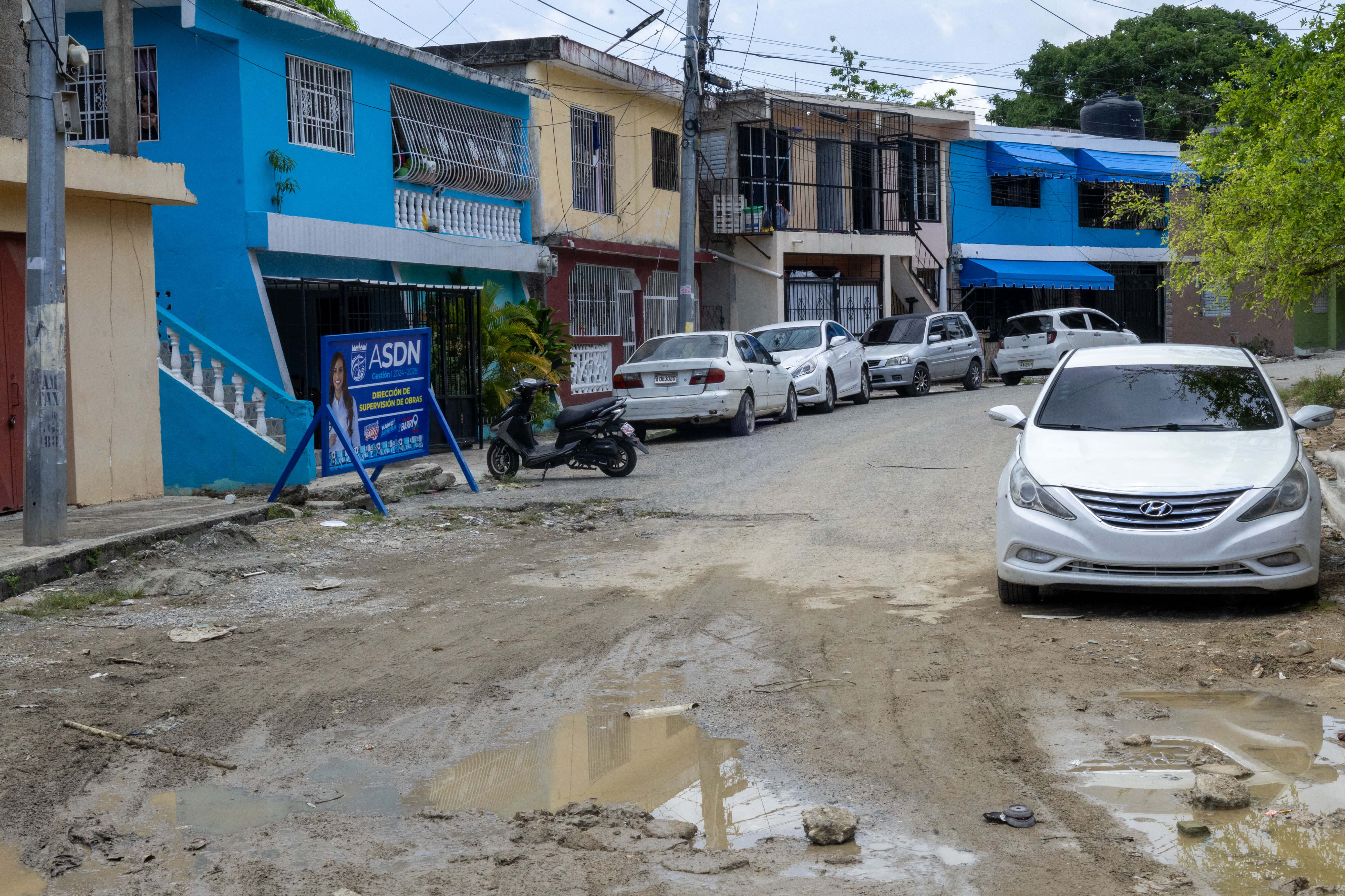 Calles con hoyos, agua estancada y lodo en el sector Primaveral de Villa Mella, este 6 de junio de 2025.