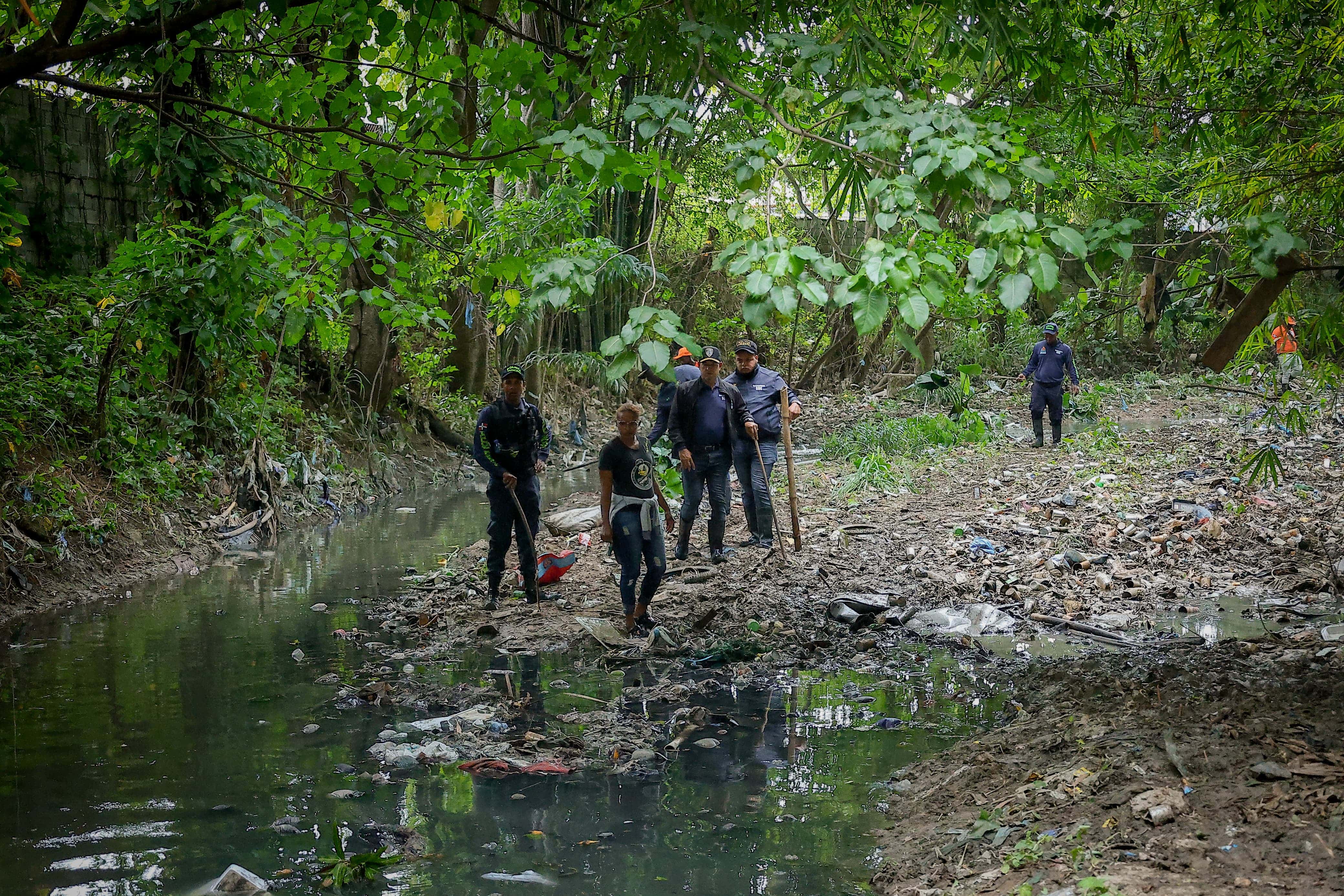 Rescatistas buscando la niña en la cañada en Villa Mella. 